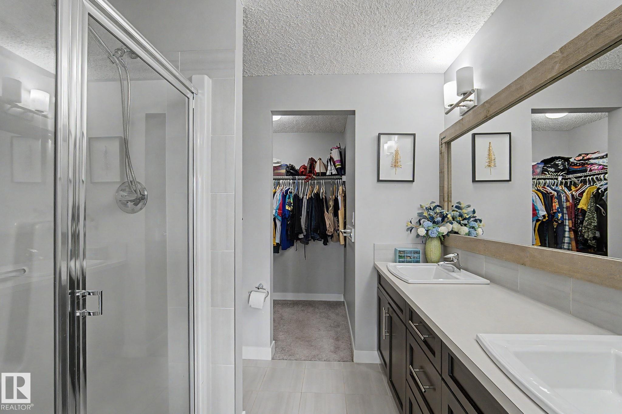 Contemporary bathroom with a glass-enclosed shower, dual vanity, and wood-finish mirror - 18144 76 Street Nw, Edmonton, AB - Indoor Photo Showing Bathroom