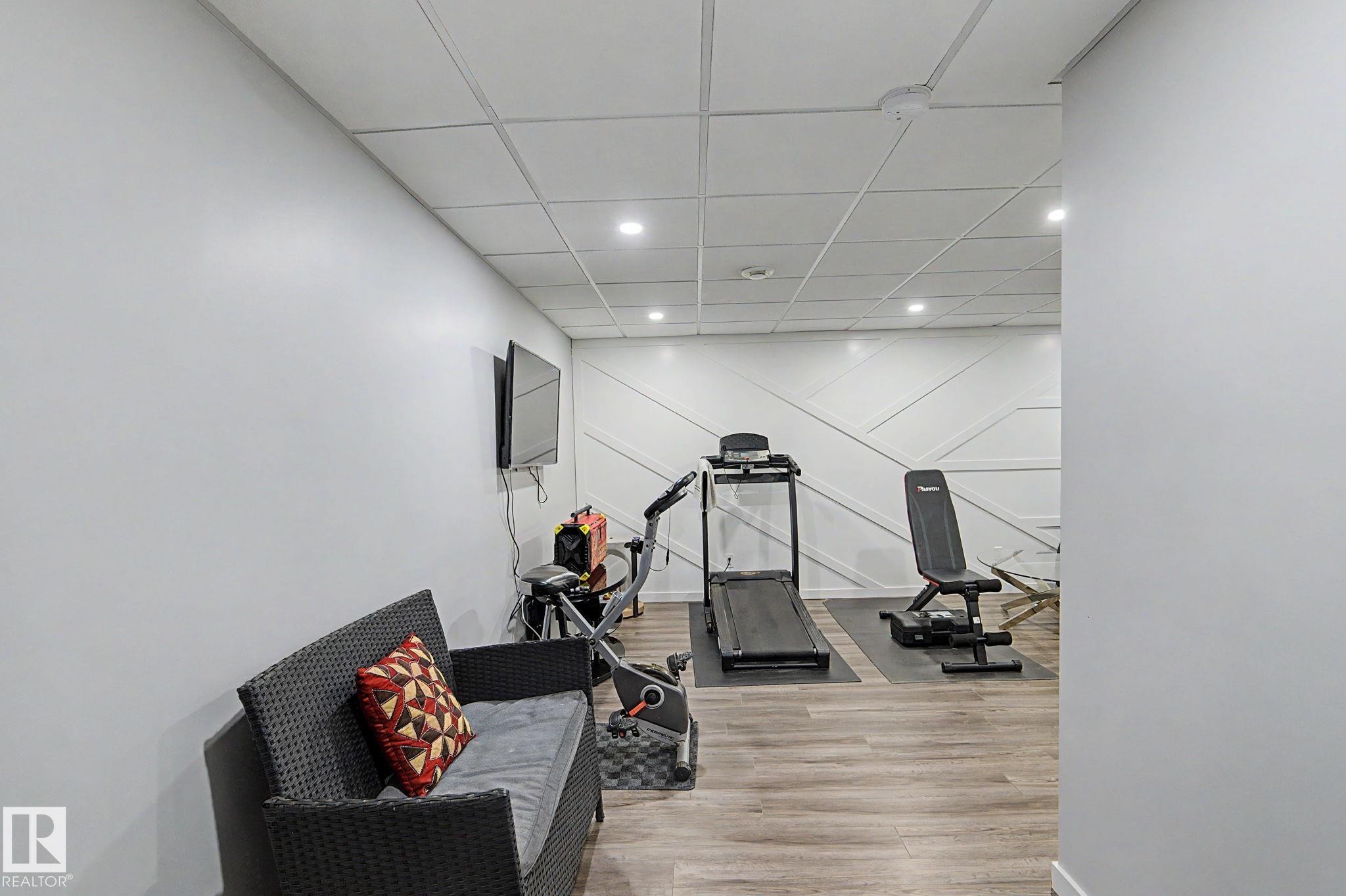 Versatile room featuring wood-finish flooring and recessed lighting - 18144 76 Street Nw, Edmonton, AB - Indoor Photo Showing Other Room