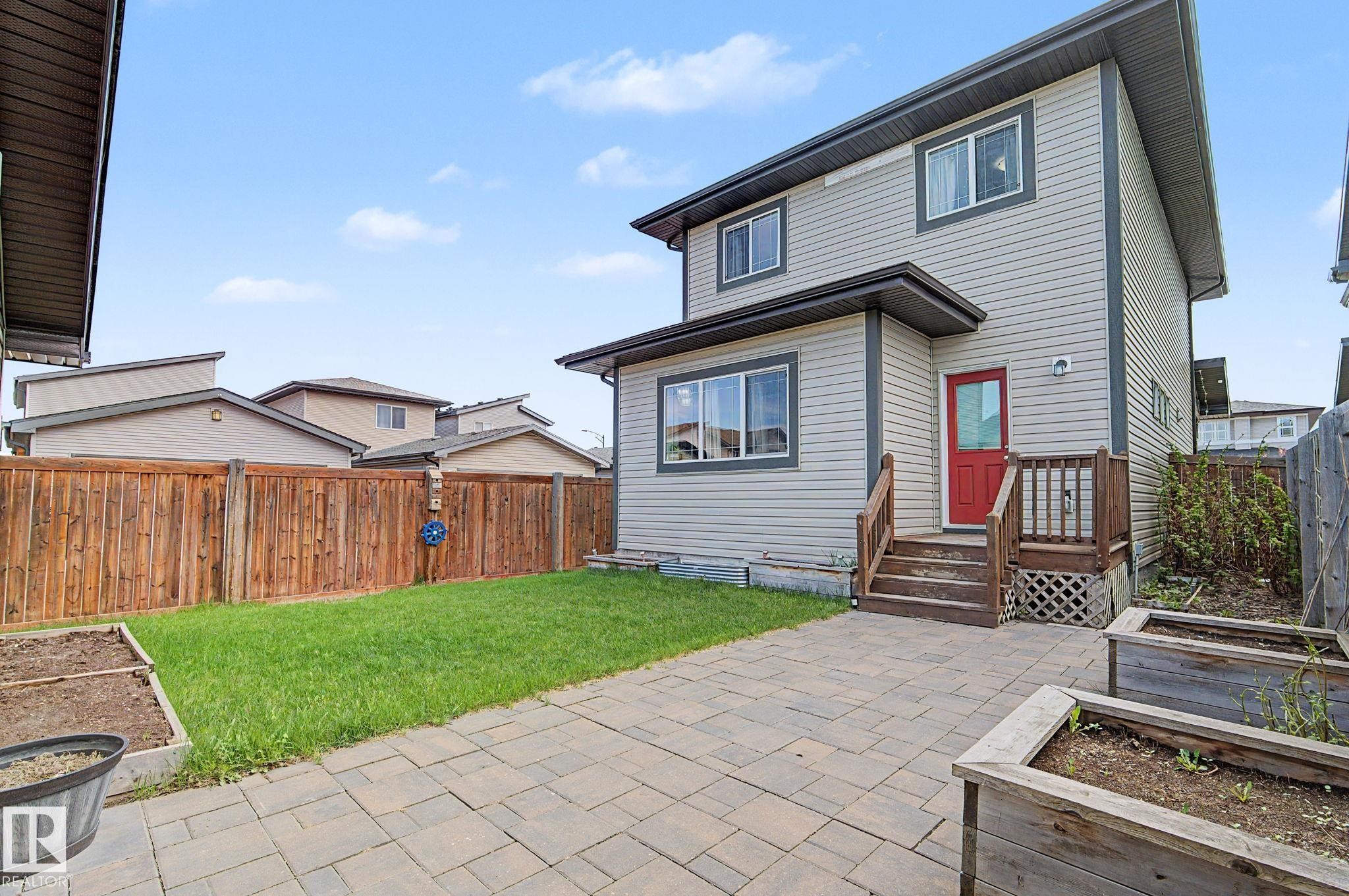 Rear exterior with light gray siding and dark trim - 18144 76 Street Nw, Edmonton, AB - Outdoor