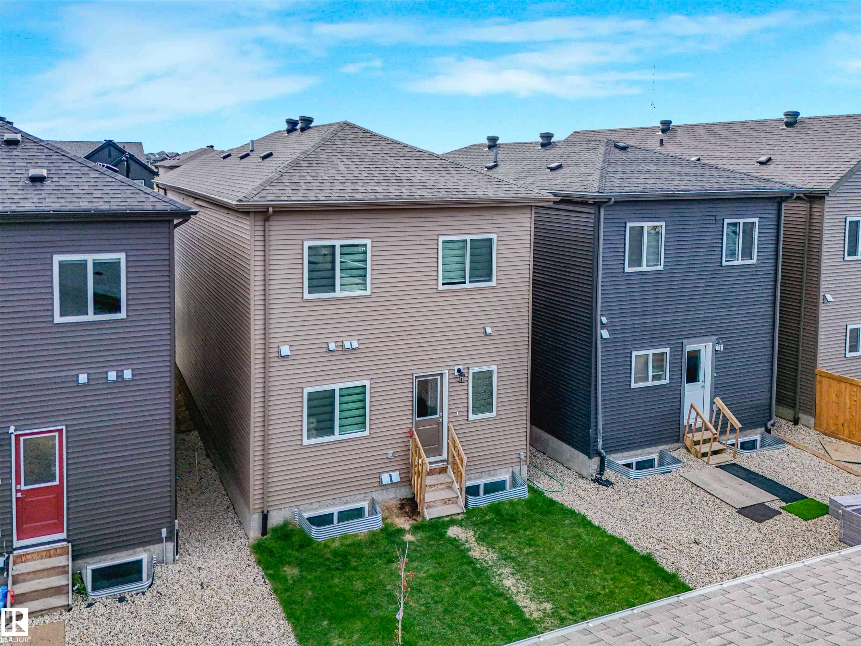 Rear elevation featuring two levels of living space with multiple windows and a neutral-toned siding - 1518 Siskin Link Link, Edmonton, AB - Outdoor With Exterior
