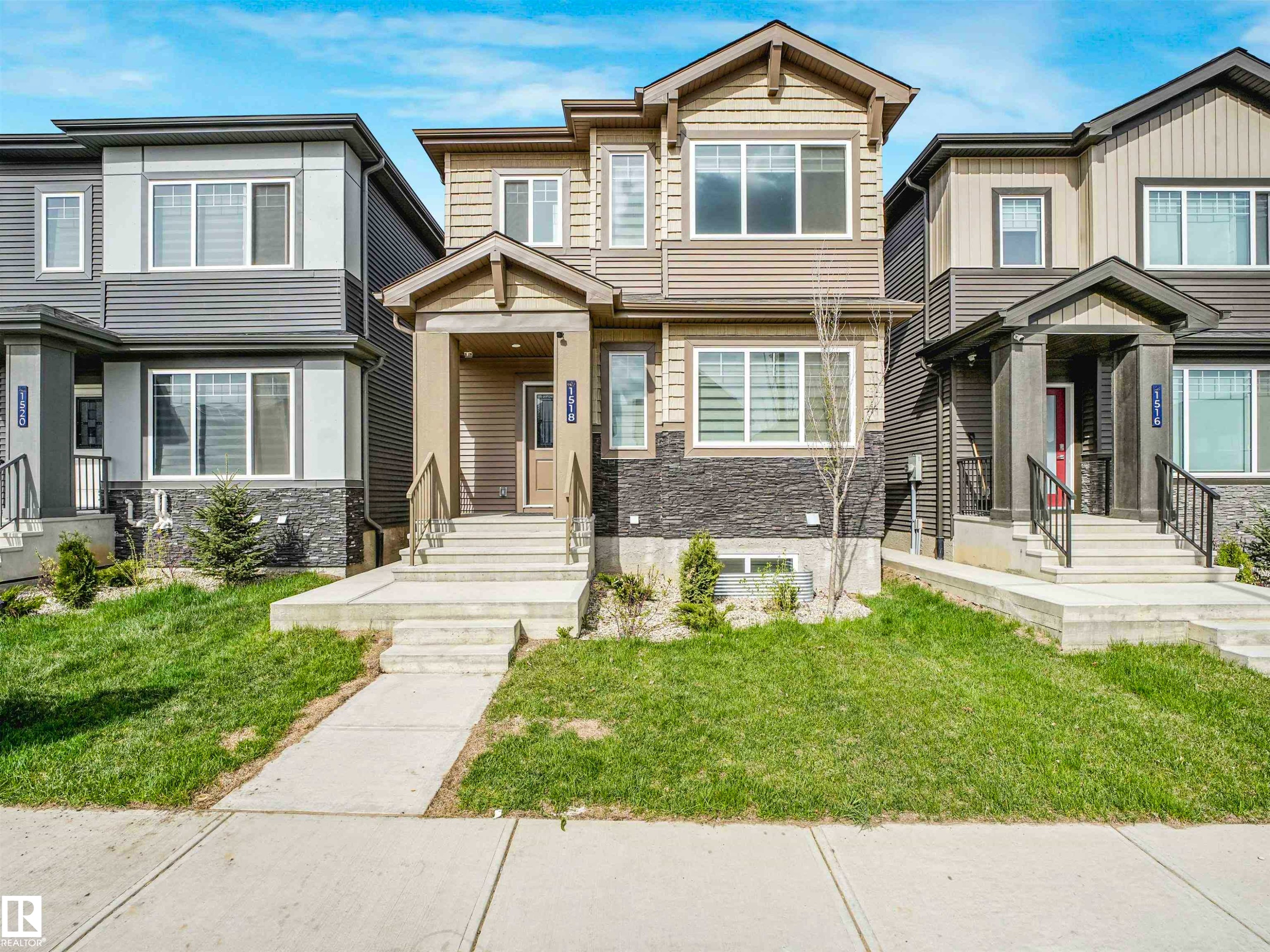 Two-story dwelling with a light-colored siding facade and dark stone accents - 1518 Siskin Link Link, Edmonton, AB - Outdoor With Facade