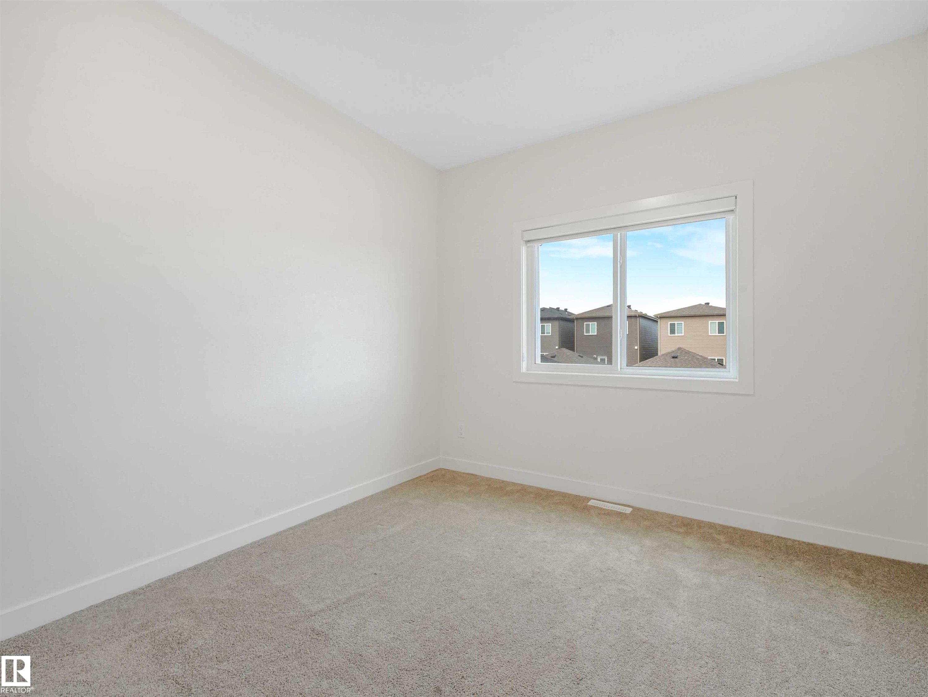 Bright interior space featuring light-colored walls and soft carpeting - 1518 Siskin Link Link, Edmonton, AB - Indoor Photo Showing Other Room