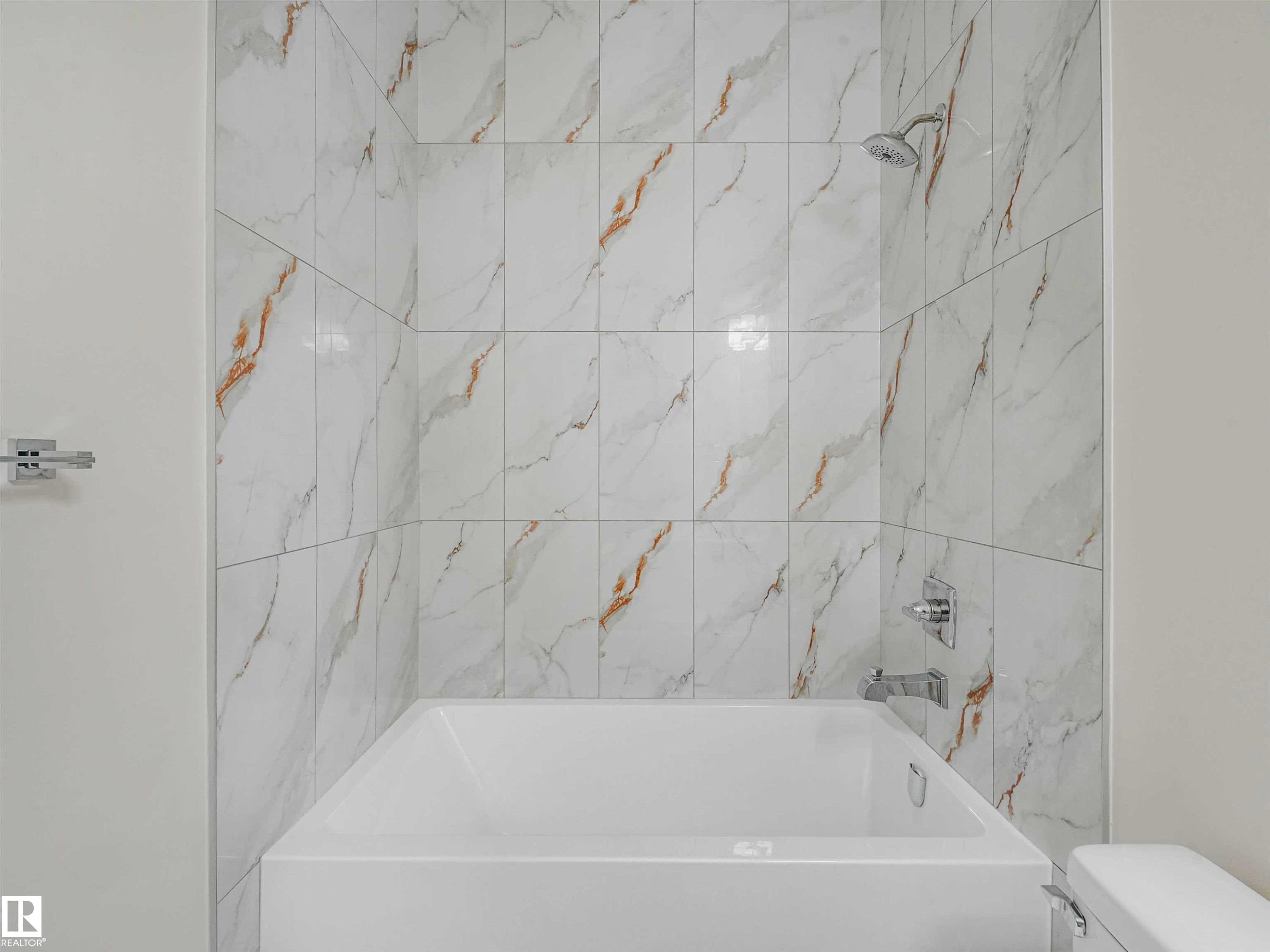 Bathtub and shower combination featuring floor-to-ceiling white and gold veined tile - 1518 Siskin Link Link, Edmonton, AB - Indoor Photo Showing Bathroom