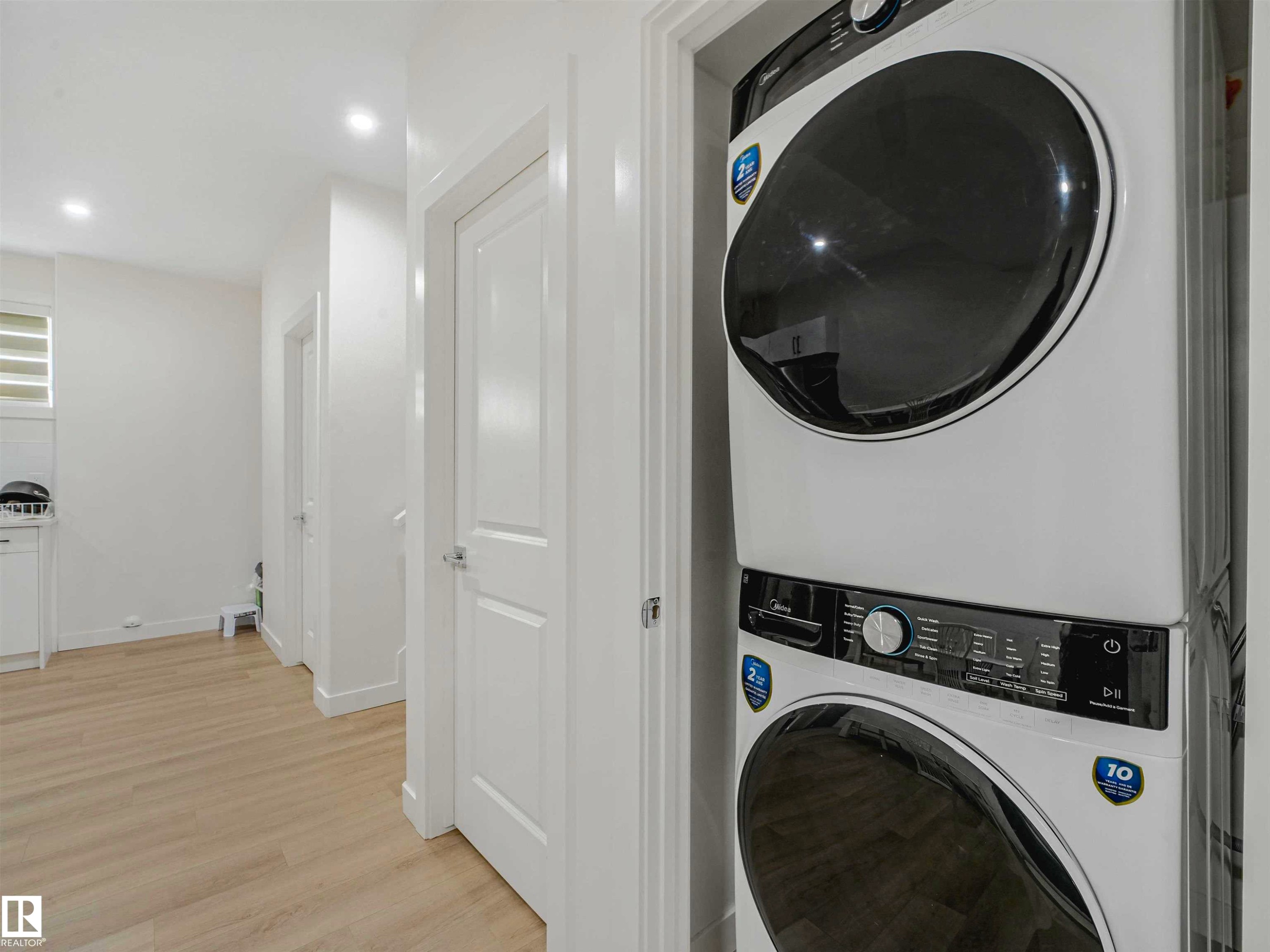 Integrated laundry closet featuring a stackable washer and dryer unit - 1518 Siskin Link Link, Edmonton, AB - Indoor Photo Showing Laundry Room