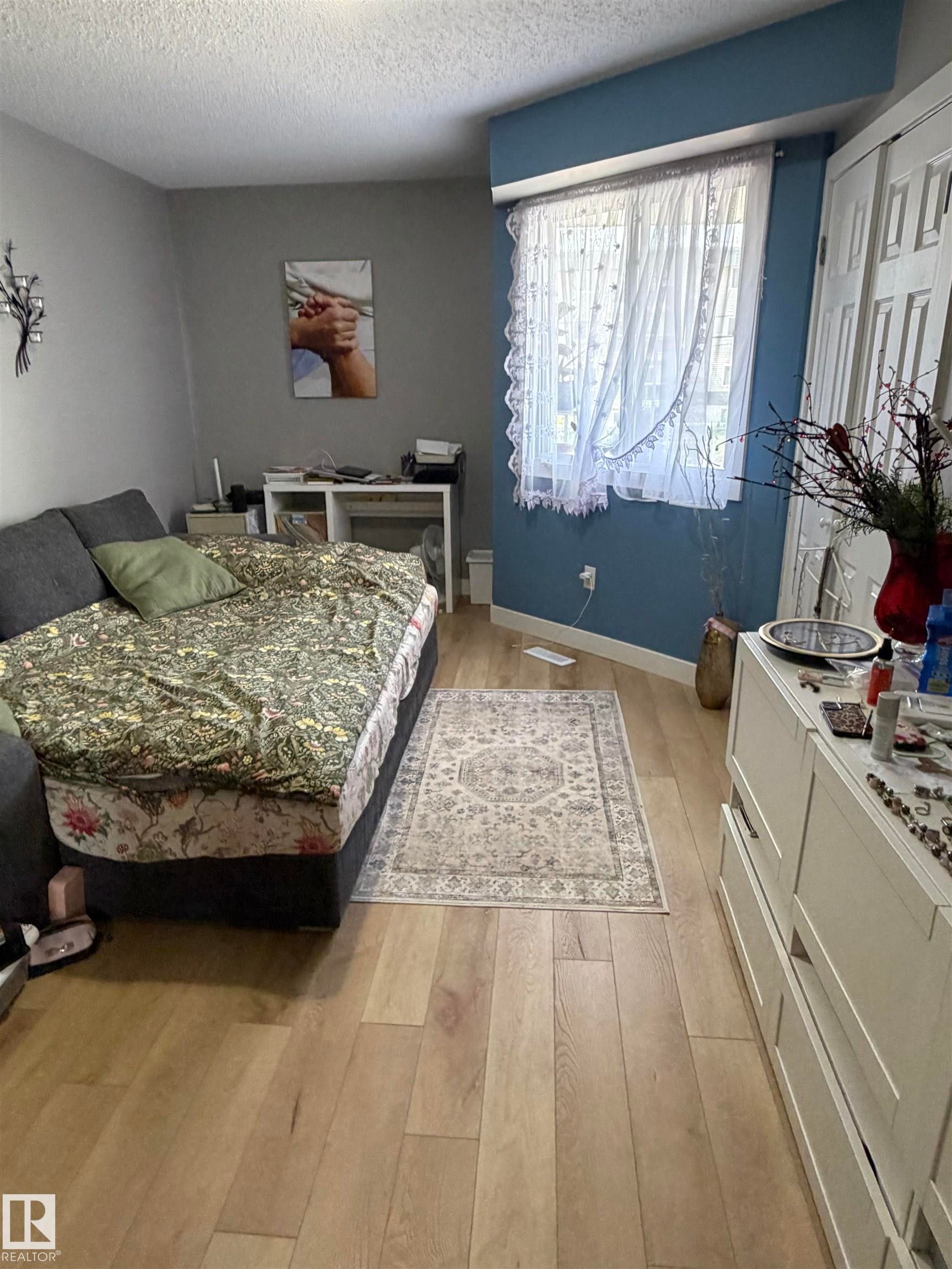 Light wood-finish flooring complements the neutral wall tones - 205 10604 110 Avenue Nw, Edmonton, AB - Indoor Photo Showing Bedroom