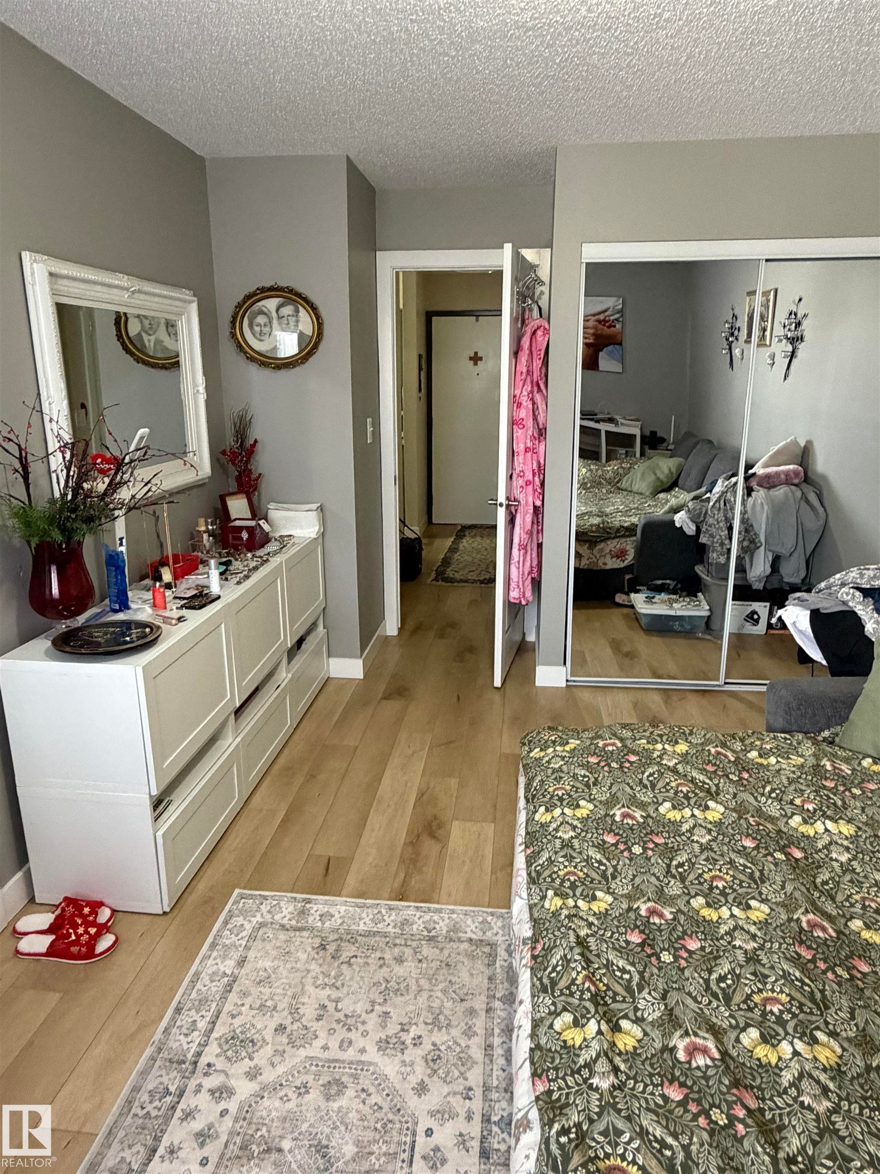 Room featuring wood-finish flooring, neutral wall tones, and white trim - 205 10604 110 Avenue Nw, Edmonton, AB - Indoor