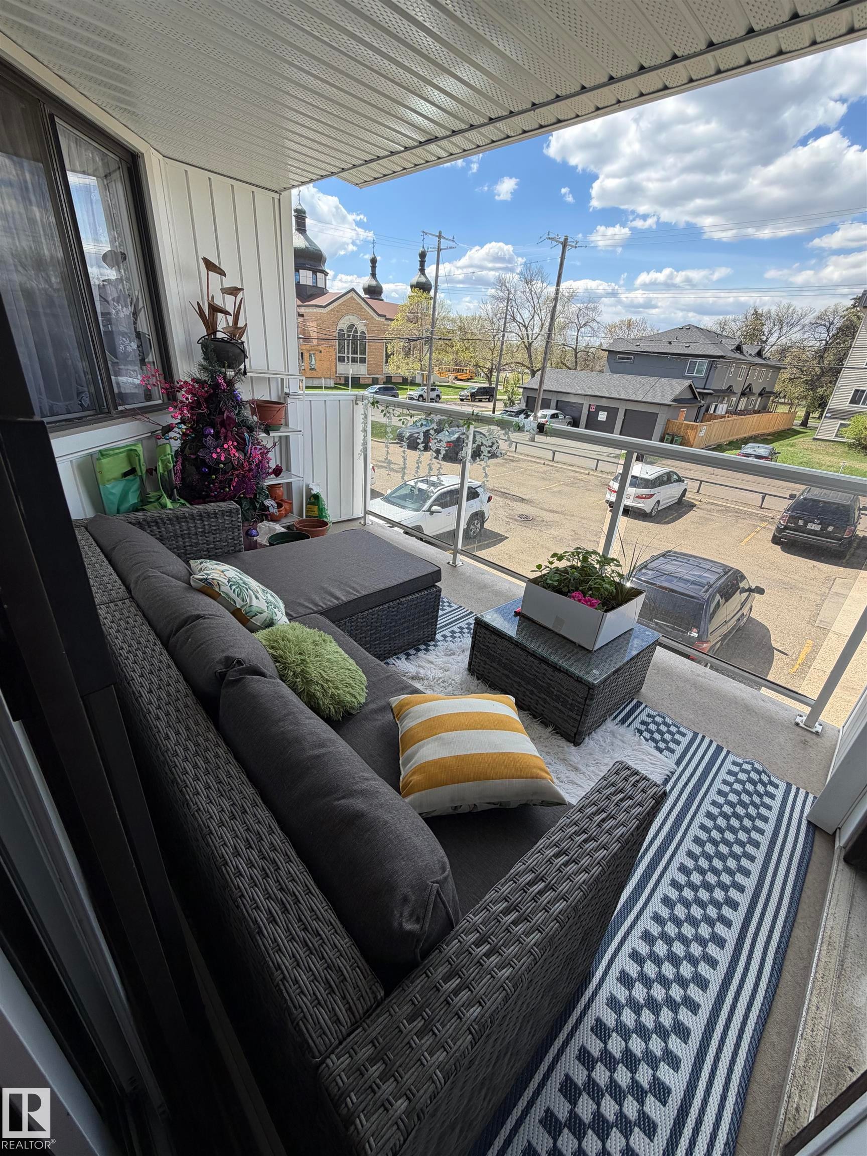 Balcony with glass railing, white vertical siding, and a textured ceiling - 205 10604 110 Avenue Nw, Edmonton, AB - Outdoor With Deck Patio Veranda