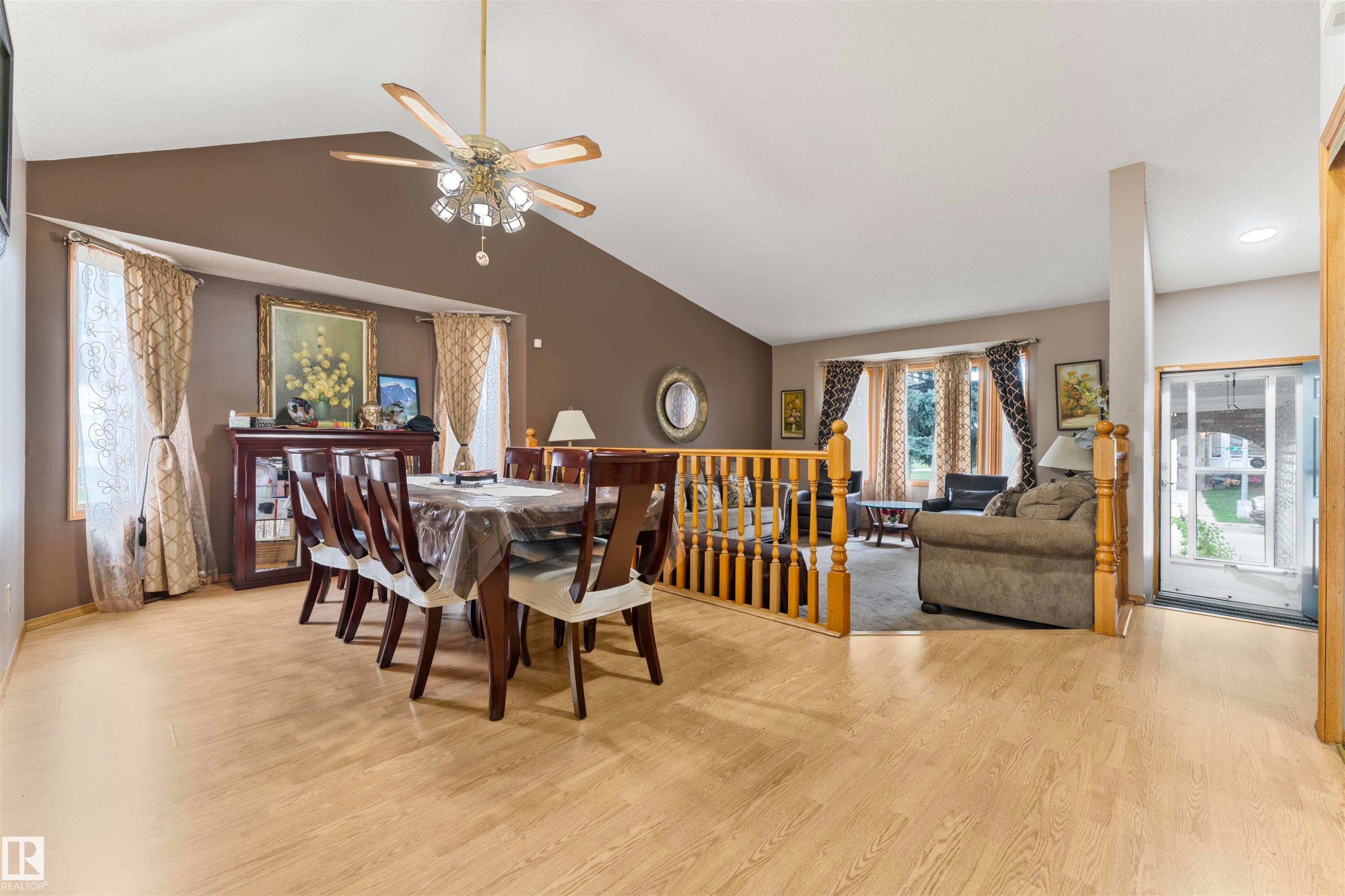 Vaulted ceiling dining area featuring wood-finish flooring, a decorative chandelier fan, and a built-in display cabinet - 4231 32 Avenue, Edmonton, AB - Indoor Photo Showing Other Room