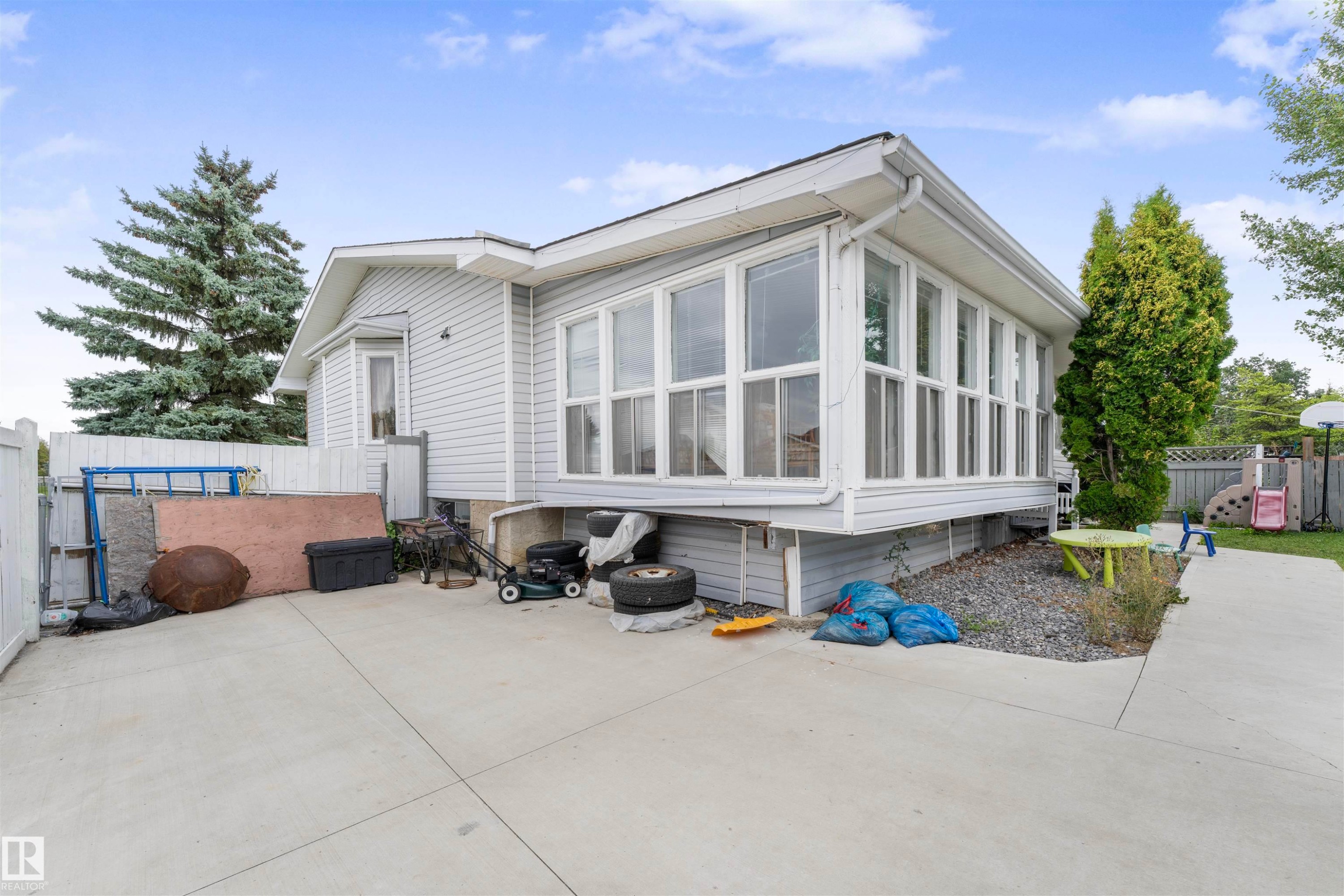 Light gray siding exterior featuring a multi-pane sunroom addition and a bay window - 4231 32 Avenue, Edmonton, AB - Outdoor