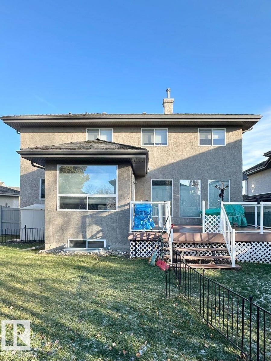 Stucco exterior featuring multiple windows and a rear deck with white railings and lattice skirting - 820 Drysdale Run, Edmonton, AB - Outdoor With Deck Patio Veranda