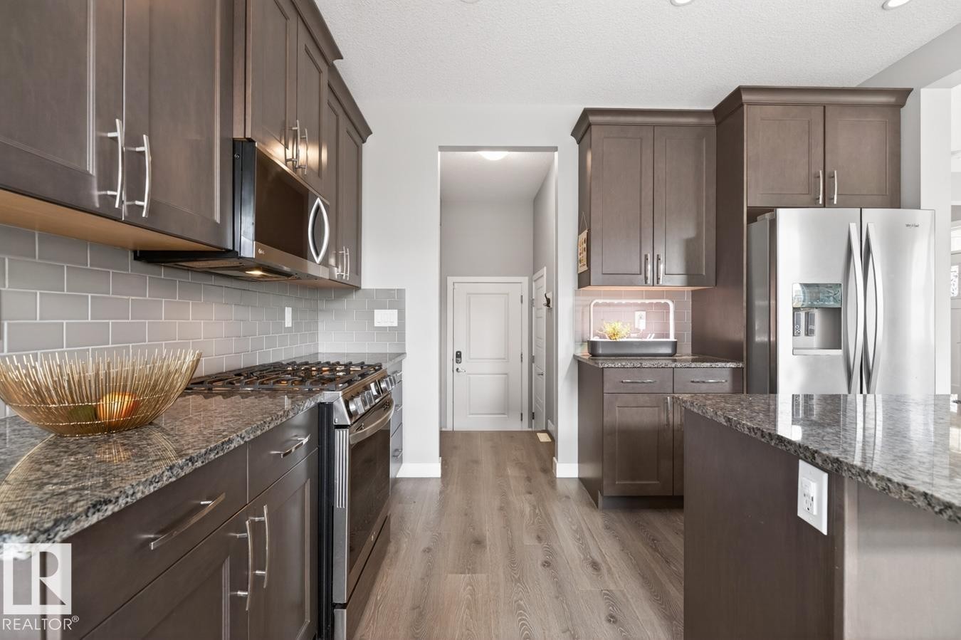 Stylish Kitchen featuring Quartz Counters, Stainless Steel Appliances (Bosh Dishwasher, Whirlpool Refrigerator, LG GAS Stove, LG Microwave Hood Fan), Subway Tile Backsplash, and plenty of Counter and Cabinet Space. - 20023 17A Avenue, Edmonton, AB - Indoor Photo Showing Kitchen With Upgraded Kitchen