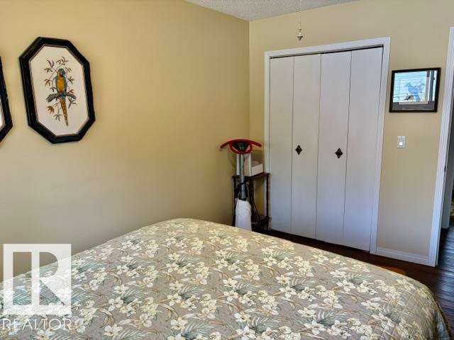 Bi-fold closet doors with diamond-shaped hardware - 4805 53Ave, Willingdon, AB - Indoor Photo Showing Bedroom