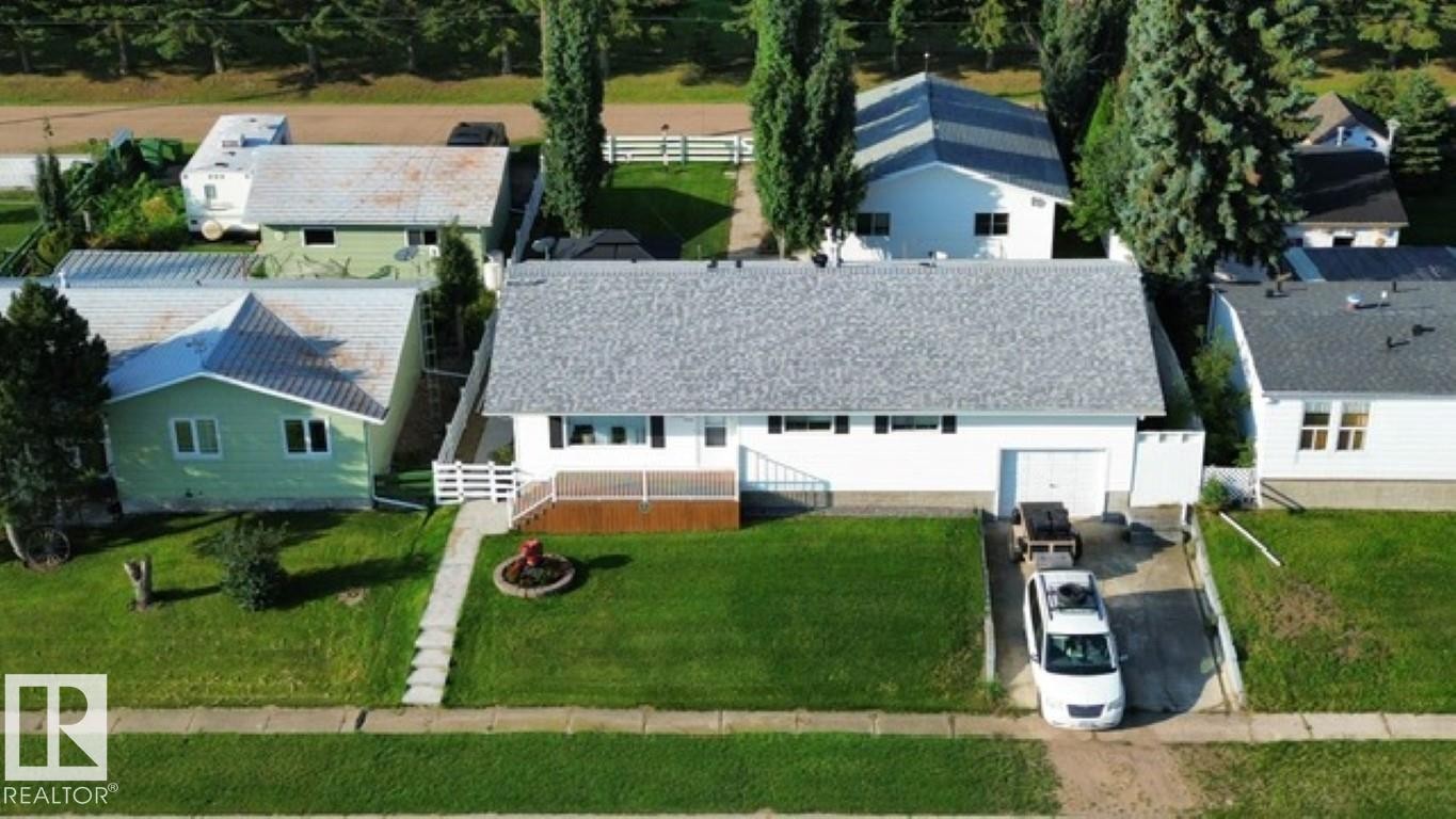 Ranch-style residence featuring a white exterior, attached single-car garage, and a front deck - 4805 53Ave, Willingdon, AB - Outdoor
