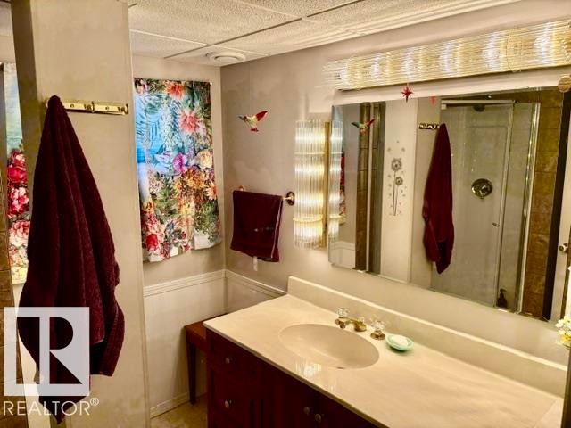 Vanity with a light-toned countertop and an undermount sink - 4805 53Ave, Willingdon, AB - Indoor Photo Showing Bathroom