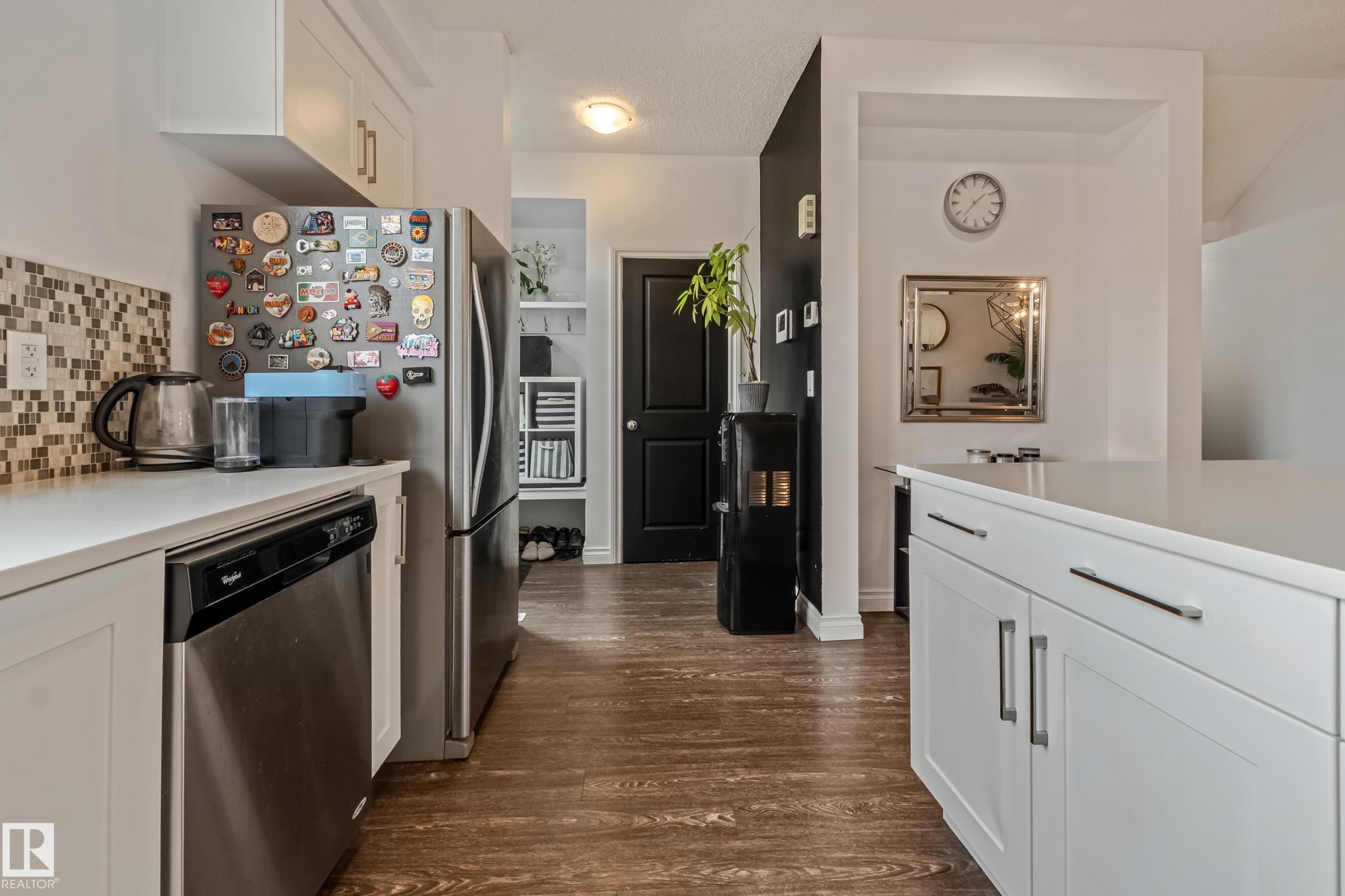 Kitchen featuring white cabinetry, stainless steel dishwasher, mosaic tile backsplash, wood-finish flooring, and a stone countertop - 8131 Chappelle Way, Edmonton, AB - Indoor Photo Showing Kitchen