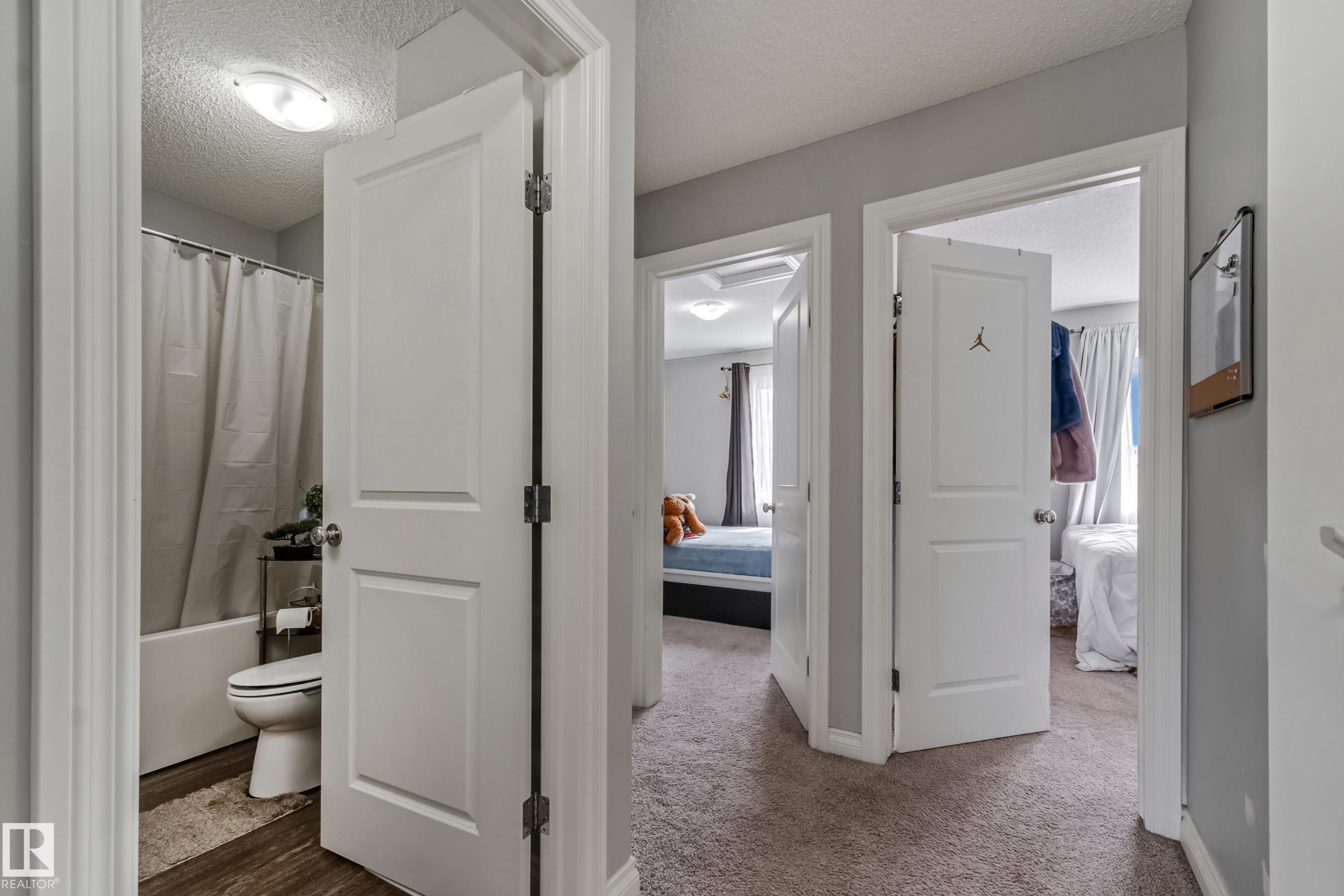 Interior hallway featuring light gray walls, white paneled doors, and plush carpet flooring - 8131 Chappelle Way, Edmonton, AB - Indoor