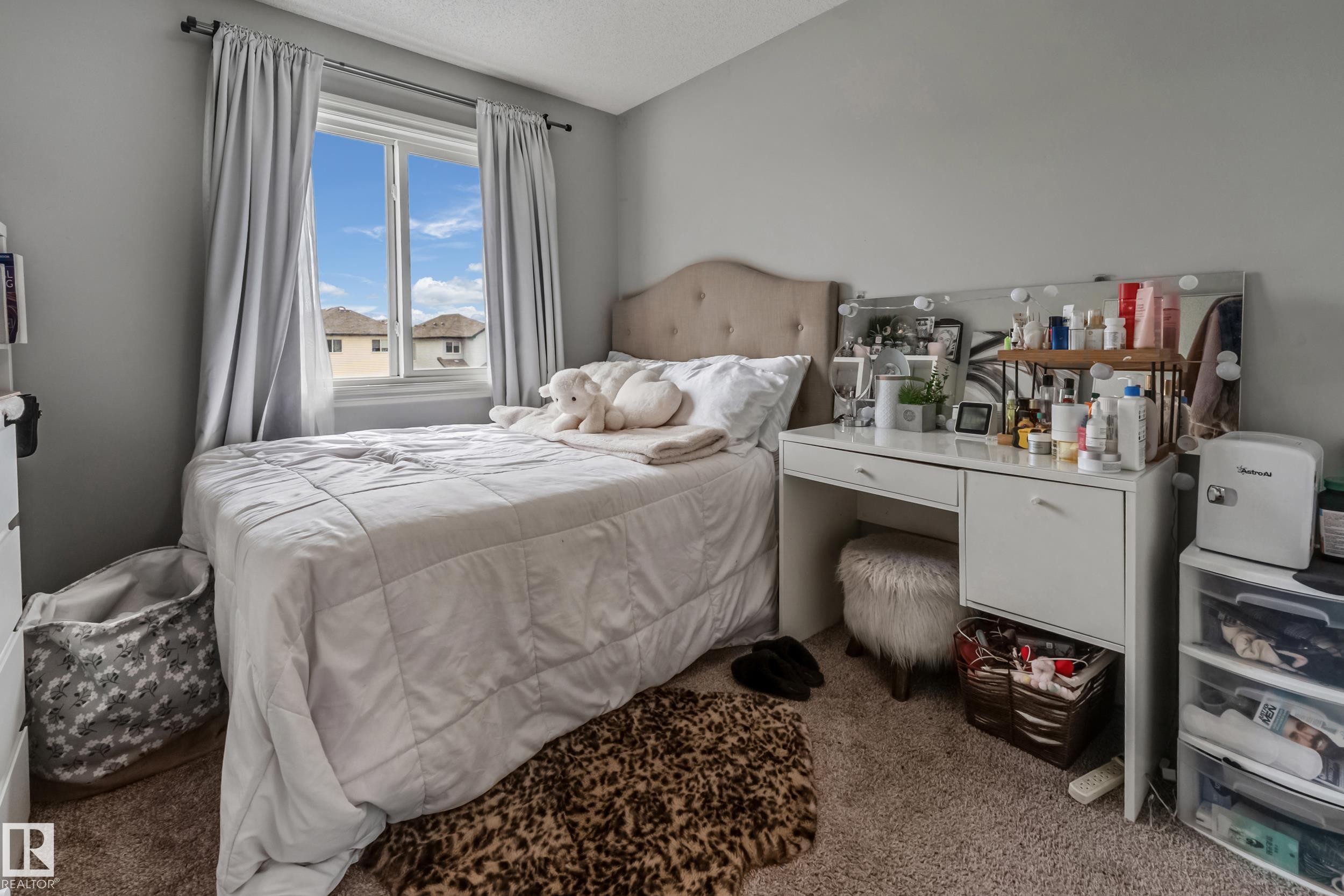 Bedroom featuring a window with natural light, light gray walls, textured carpet flooring, and a built-in vanity with storage - 8131 Chappelle Way, Edmonton, AB - Indoor Photo Showing Bedroom