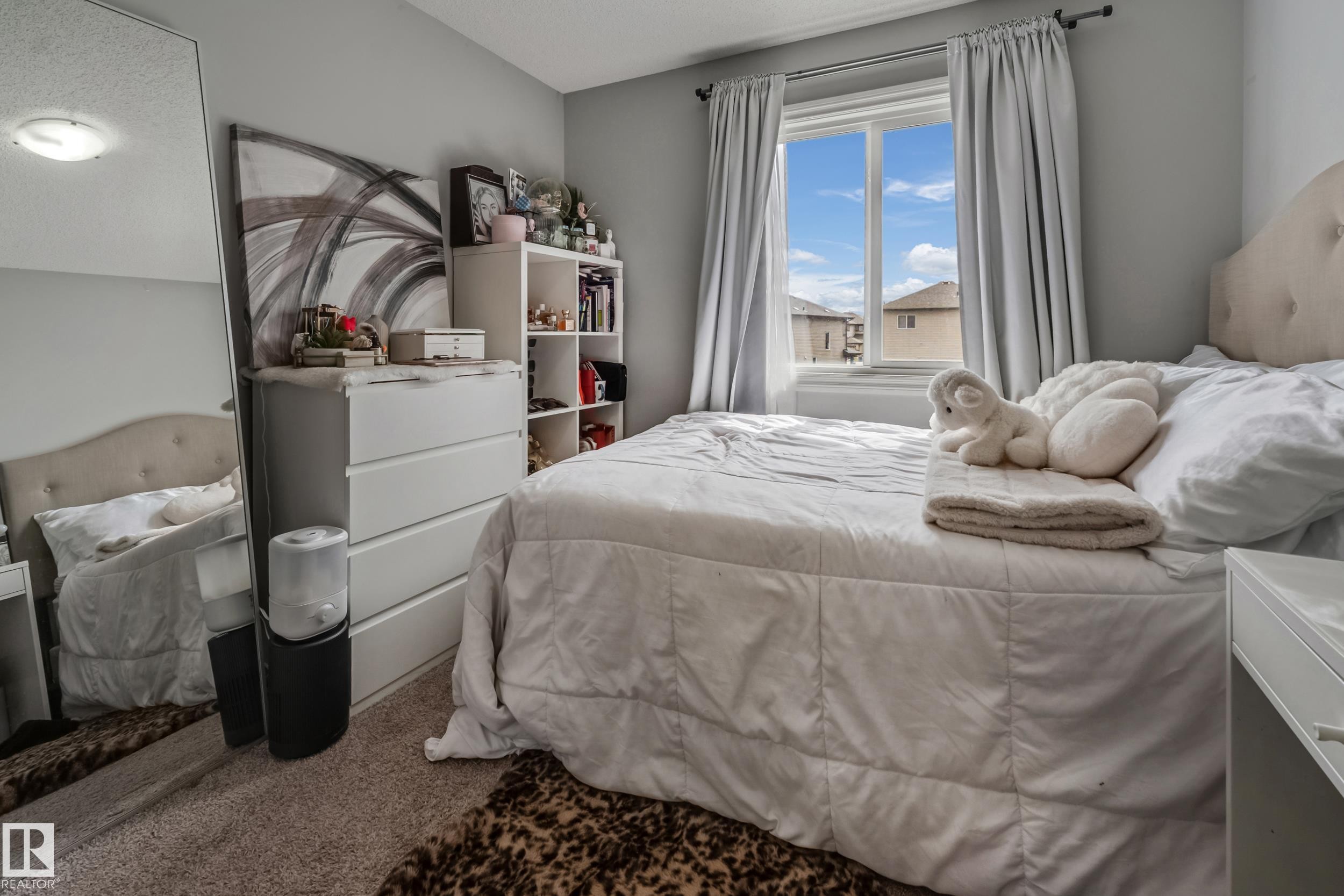 Carpeted bedroom featuring a window with natural light, neutral wall paint, and a built-in ceiling light fixture - 8131 Chappelle Way, Edmonton, AB - Indoor Photo Showing Bedroom