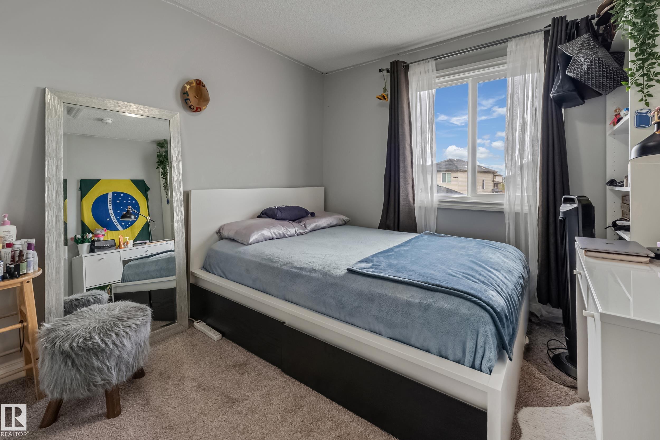 Carpeted room featuring a window with white trim, a built-in shelving unit, and neutral wall paint - 8131 Chappelle Way, Edmonton, AB - Indoor Photo Showing Bedroom