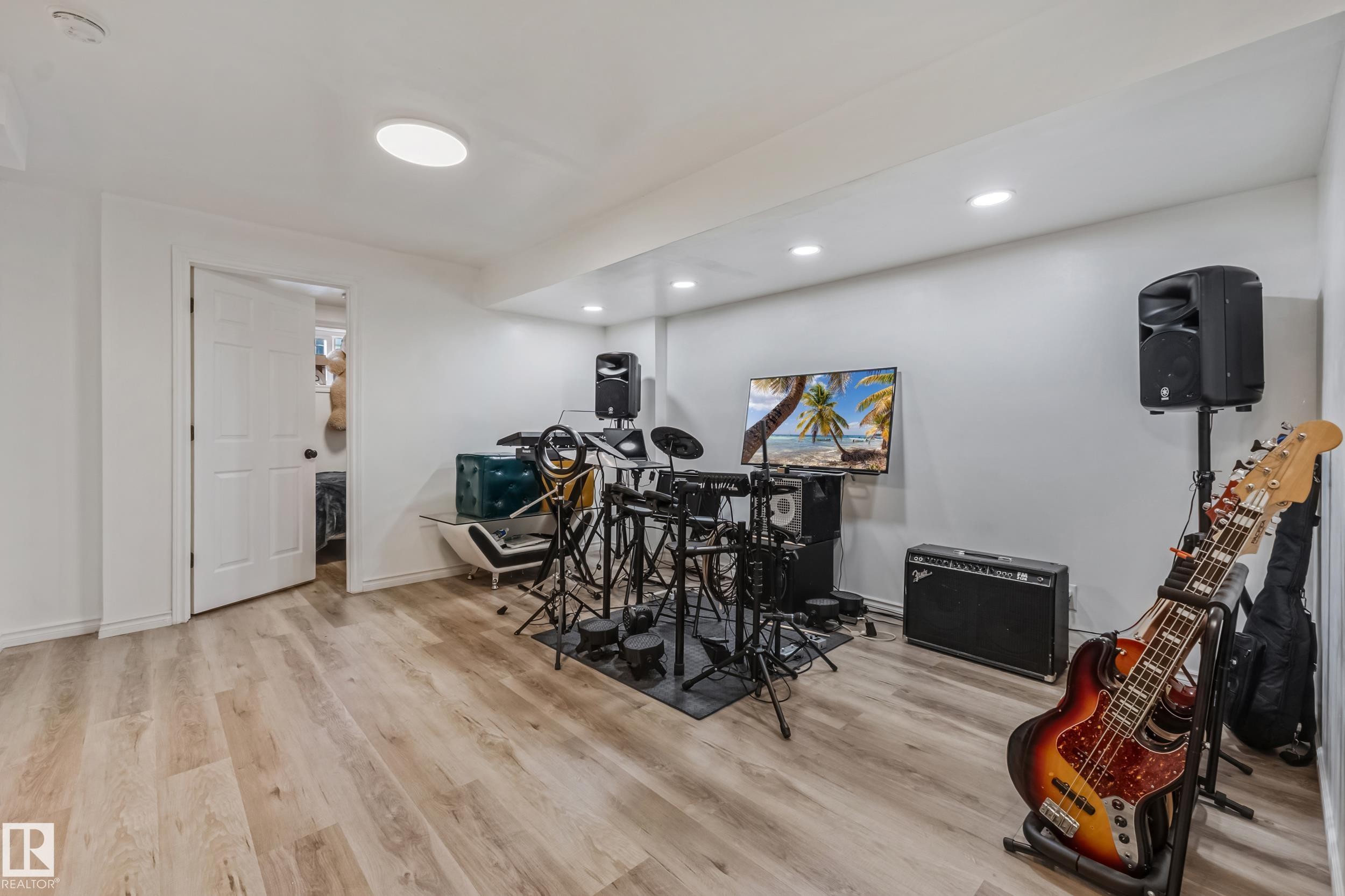 Spacious room featuring wood-finish flooring, recessed lighting, and a neutral color palette - 8131 Chappelle Way, Edmonton, AB - Indoor