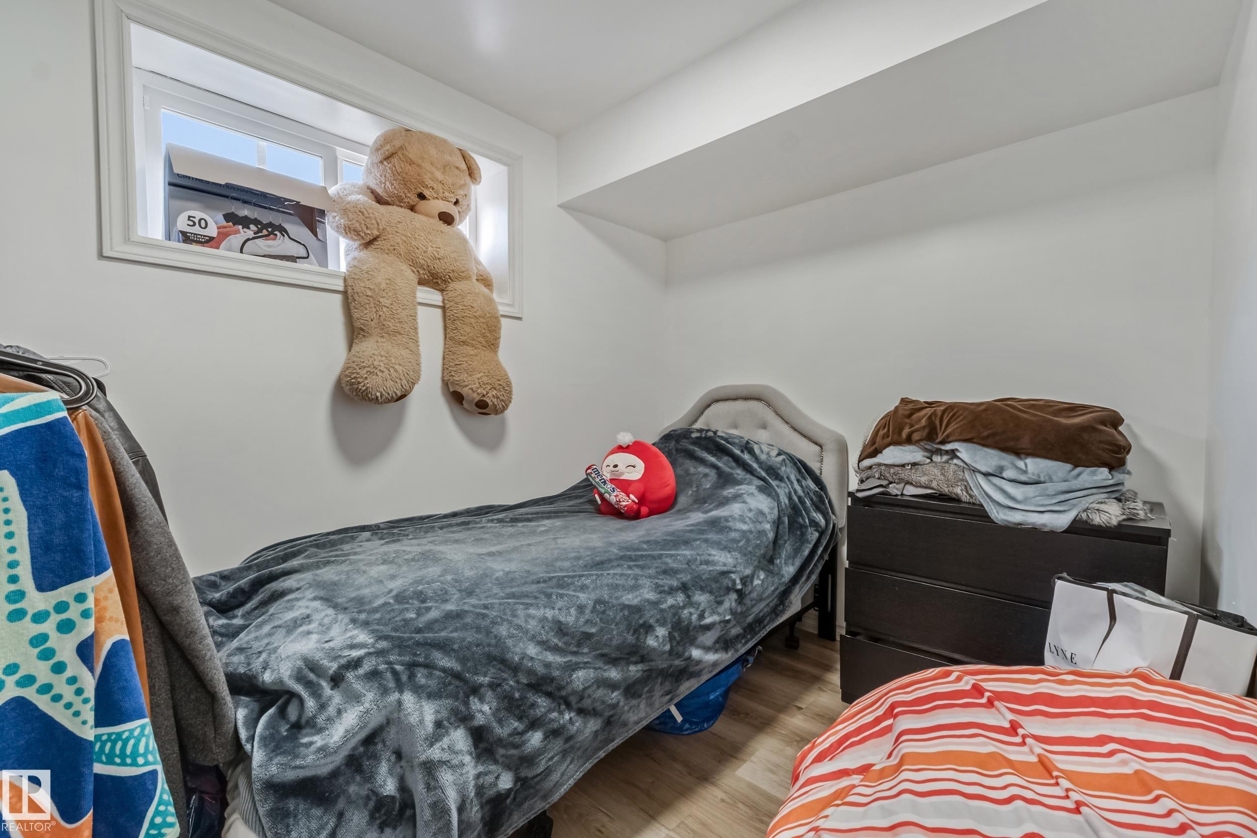 White walls and light wood-finish flooring provide a neutral backdrop for customization - 8131 Chappelle Way, Edmonton, AB - Indoor Photo Showing Bedroom