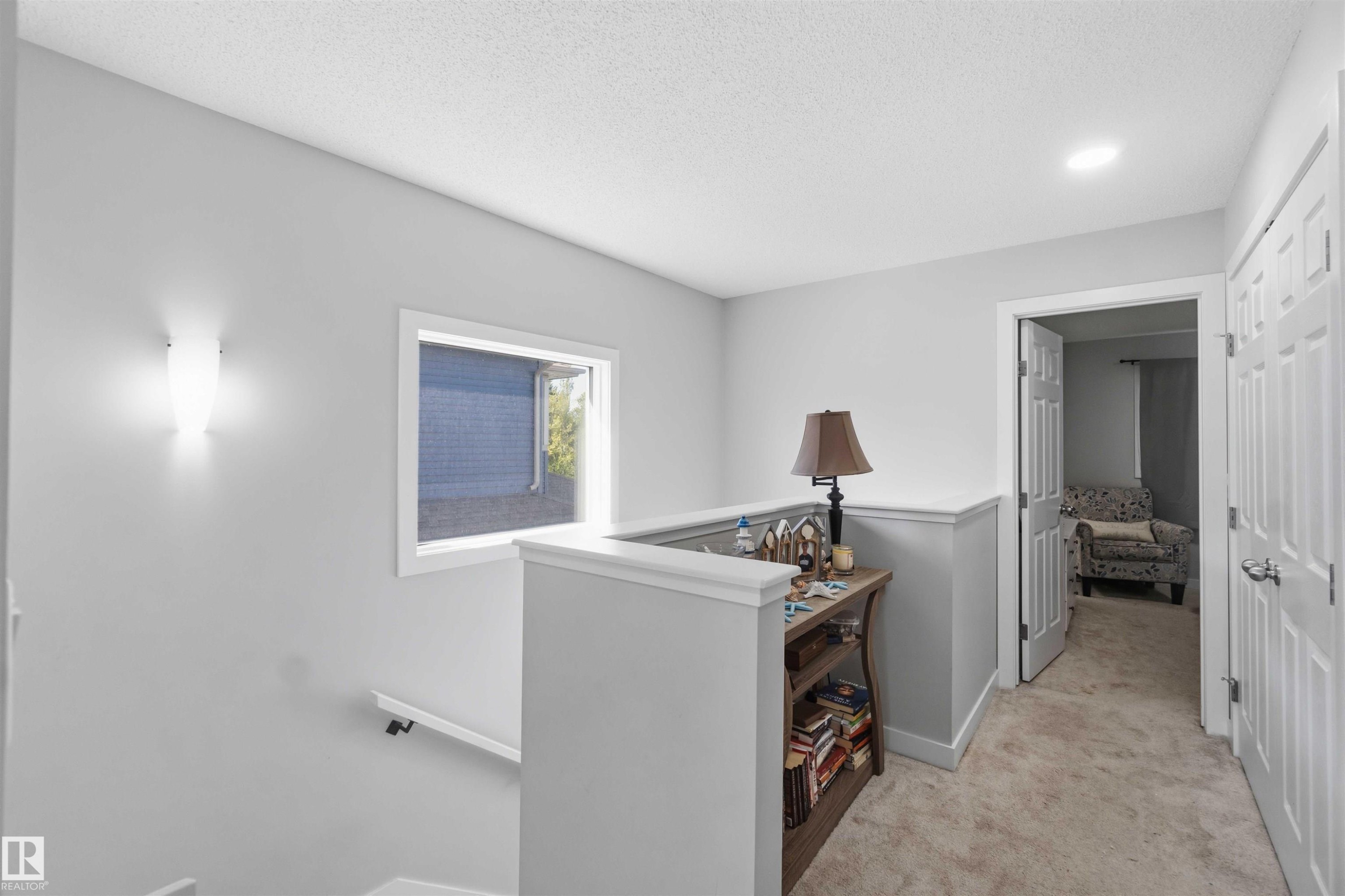 Upper-level landing featuring a half-wall balustrade, a window, and recessed lighting - 5129 Lark Crescent, Edmonton, AB - Indoor