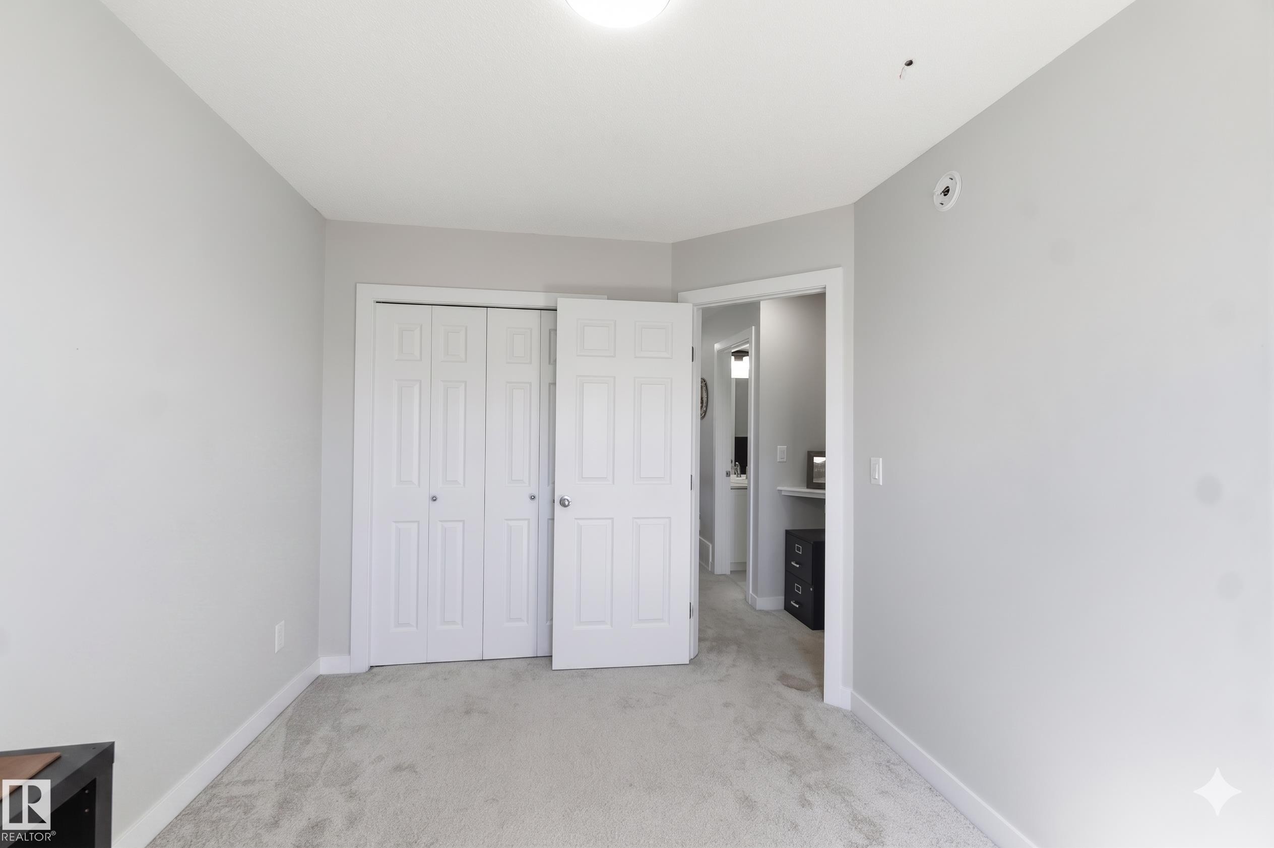 Room featuring light gray walls, white baseboards, and neutral-toned carpeting - 5129 Lark Crescent, Edmonton, AB - Indoor Photo Showing Other Room