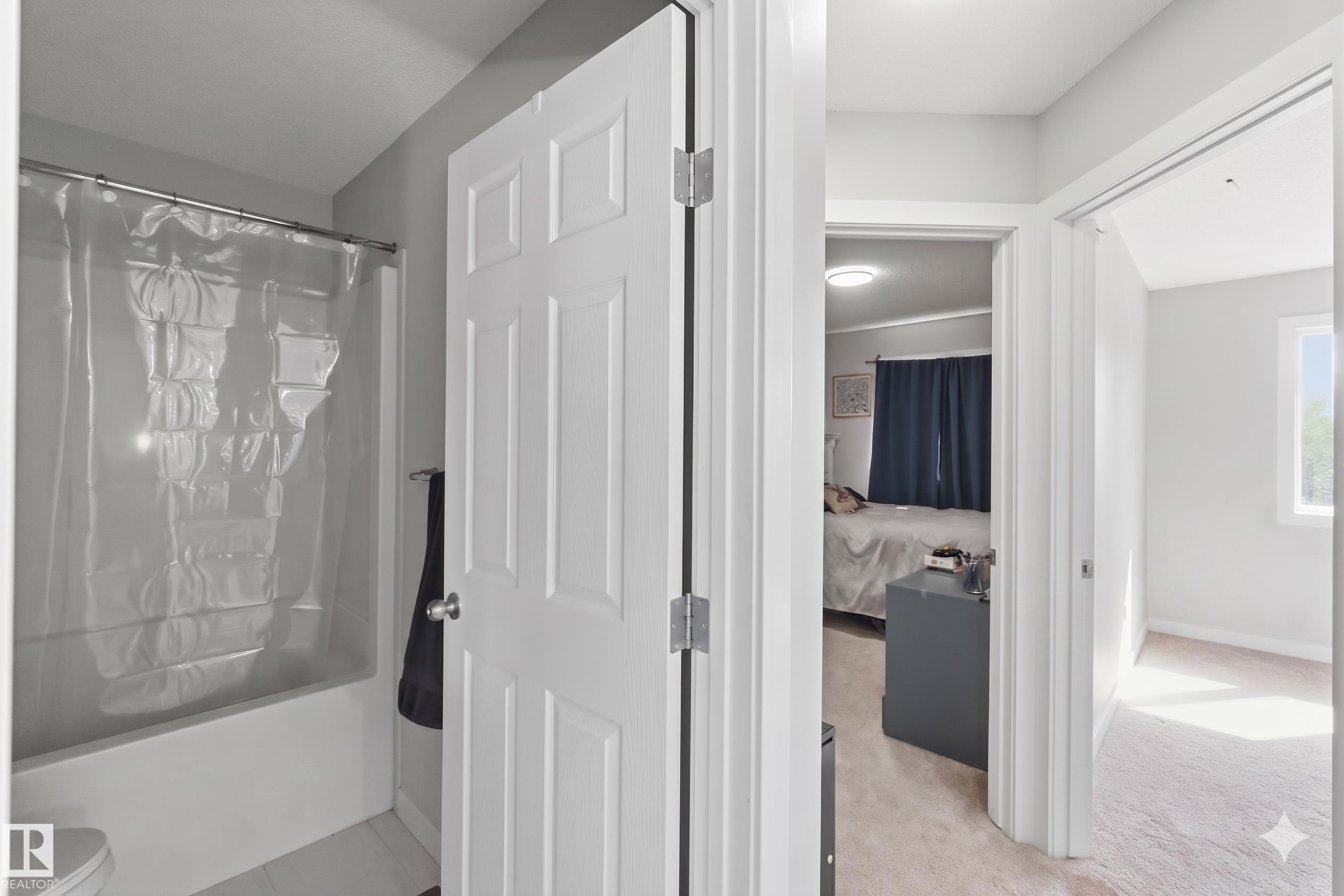 Full bathroom featuring a shower-over-tub combination with a clear shower curtain - 5129 Lark Crescent, Edmonton, AB - Indoor Photo Showing Other Room
