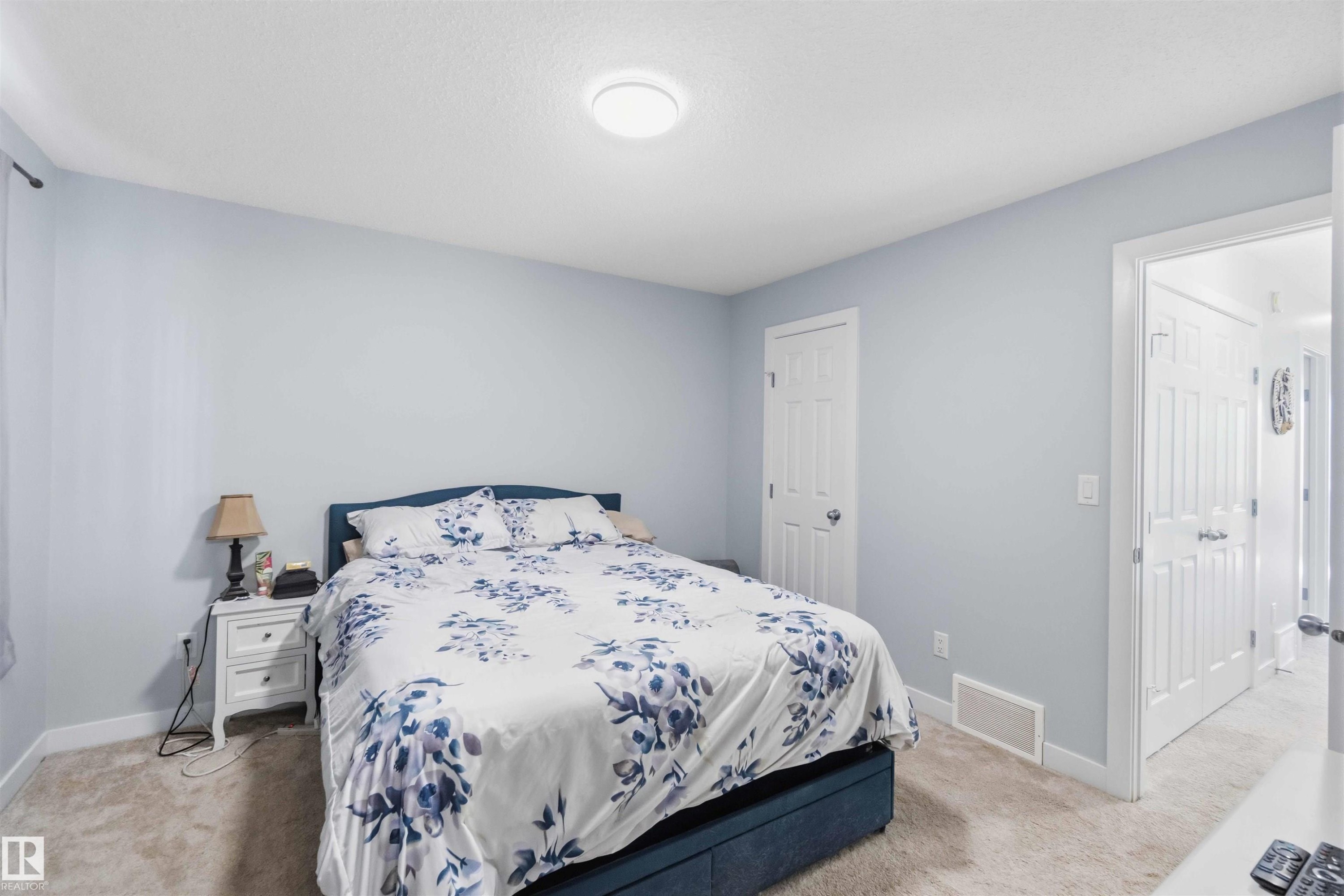 Spacious room featuring light blue walls and neutral carpet flooring - 5129 Lark Crescent, Edmonton, AB - Indoor Photo Showing Bedroom