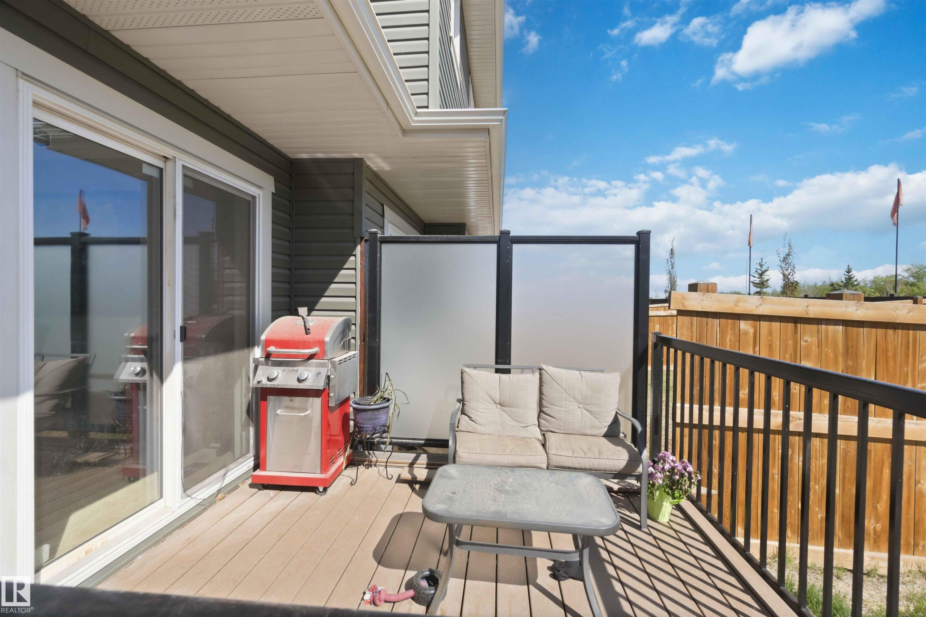 Outdoor deck featuring wood-finish flooring and black metal railings - 5129 Lark Crescent, Edmonton, AB - Outdoor With Exterior
