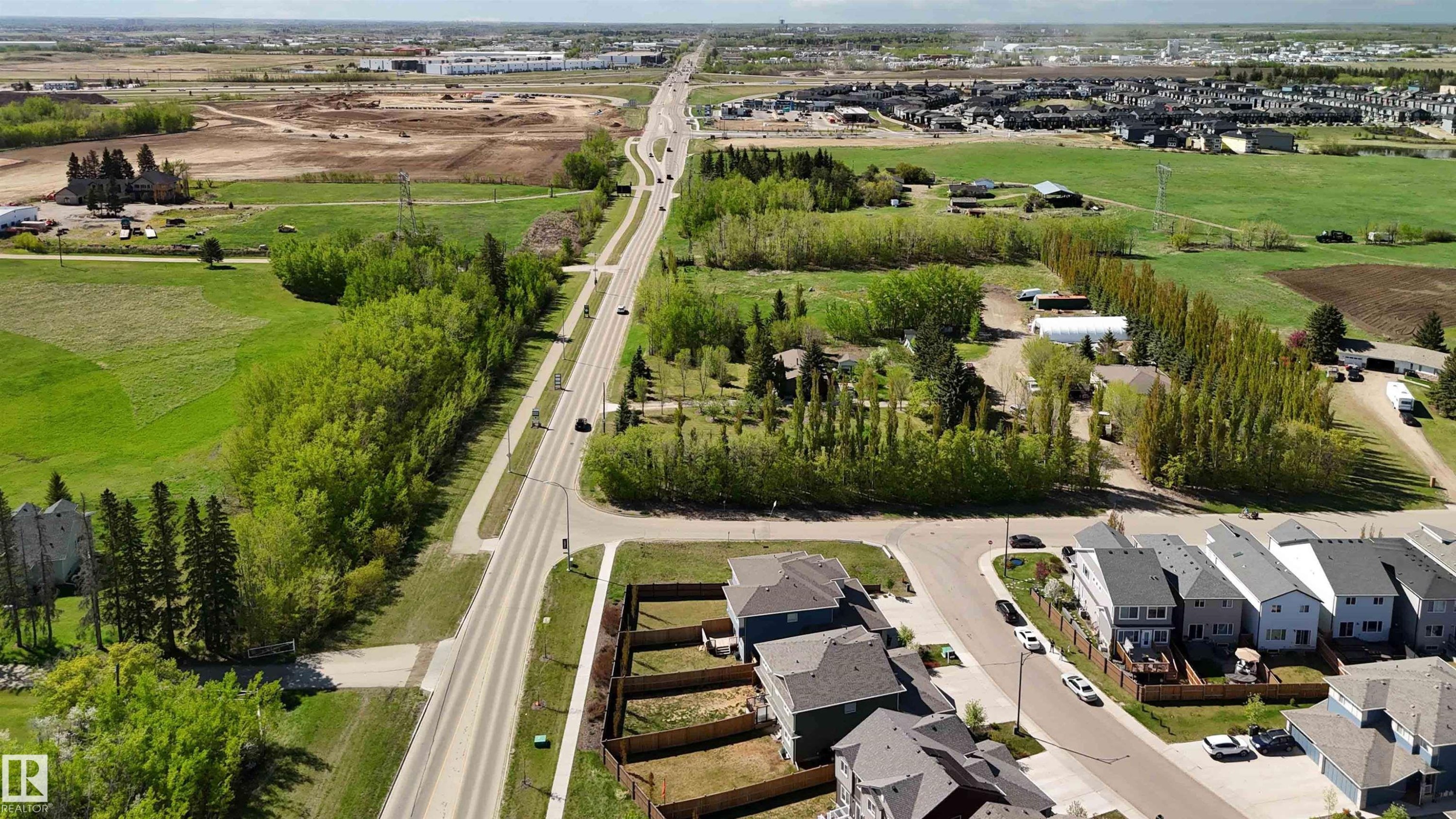 Aerial perspective showcasing a residential development bordering a tree-lined thoroughfare - 5129 Lark Crescent, Edmonton, AB - Outdoor With View