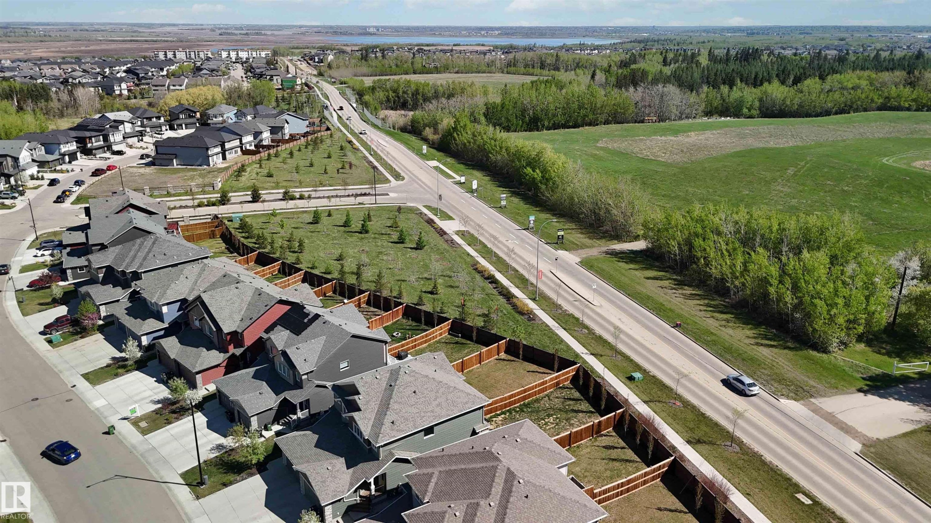 Aerial perspective highlighting a residential development bordered by open green spaces and wooded areas - 5129 Lark Crescent, Edmonton, AB - Outdoor With View