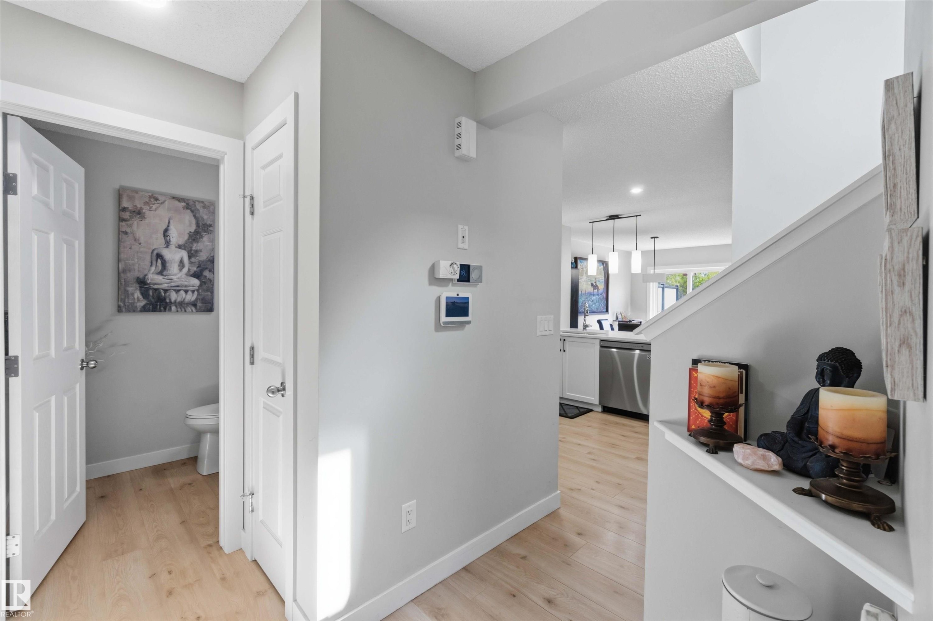 Entryway with wood-finish flooring, white trim, and light gray wall paint - 5129 Lark Crescent, Edmonton, AB - Indoor Photo Showing Other Room