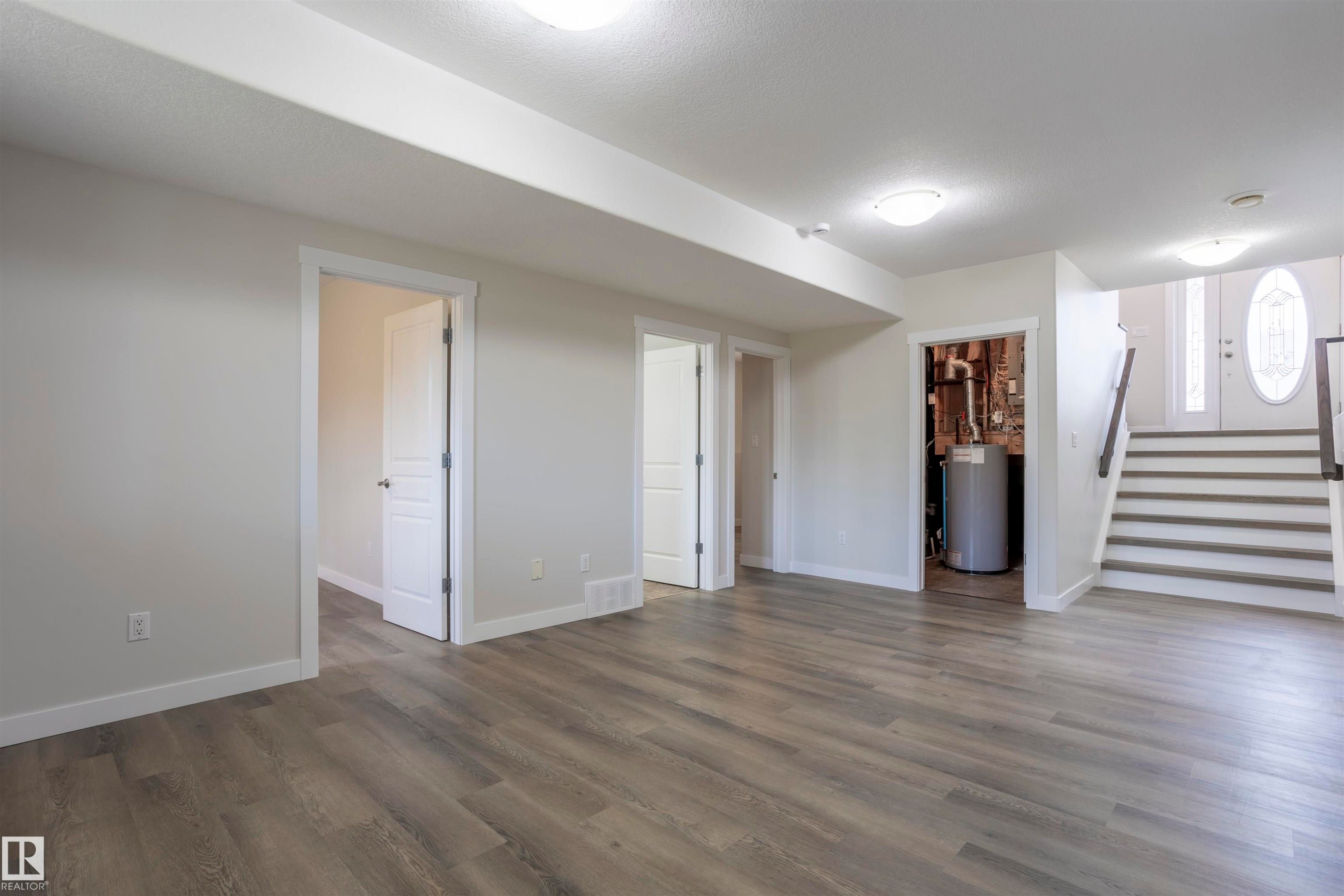 Spacious interior room featuring wood-finish flooring, white trim, and recessed lighting - 738 Kananaskis Drive, Devon, AB - Indoor Photo Showing Other Room