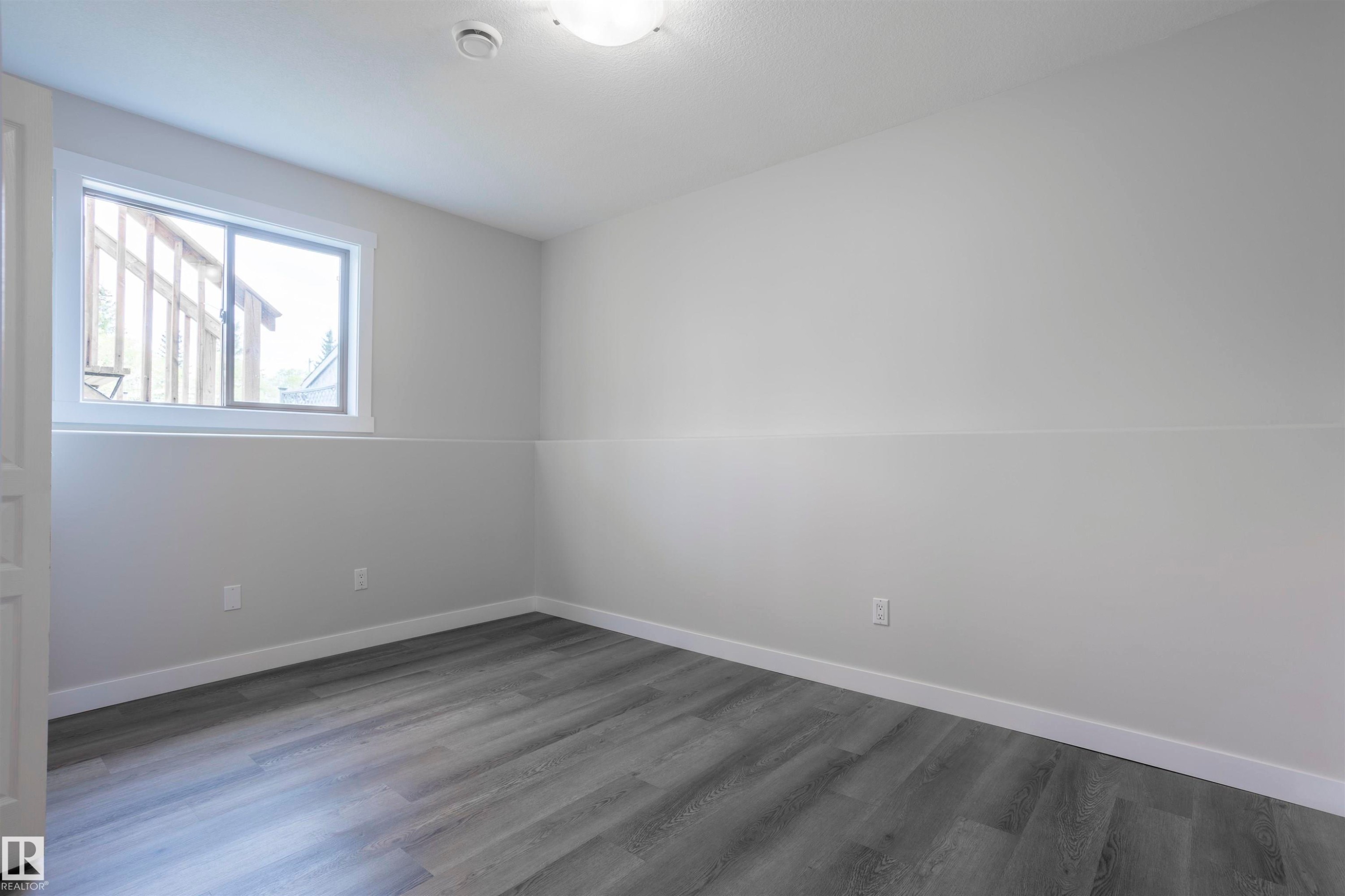 Neutral-toned room featuring a single window, recessed lighting, and wood-finish flooring - 738 Kananaskis Drive, Devon, AB - Indoor Photo Showing Other Room