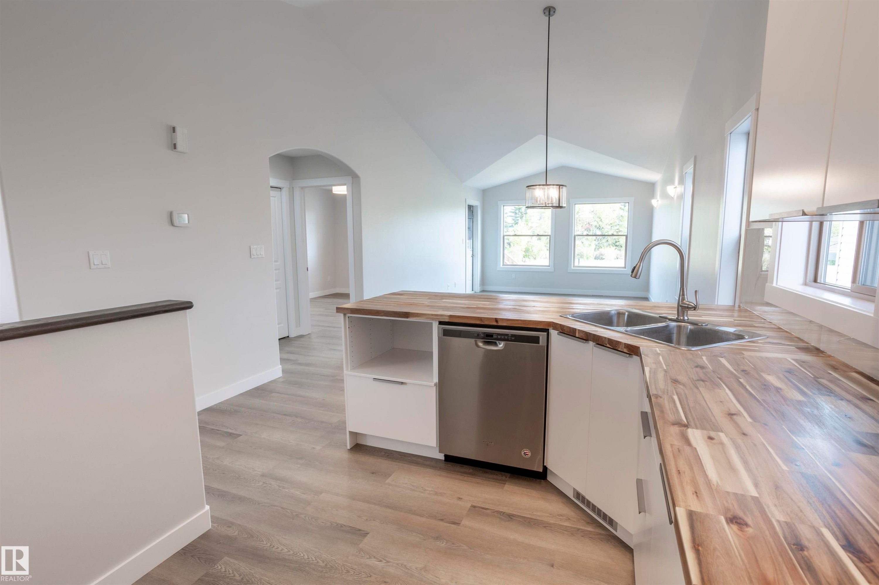 Kitchen featuring wood-finish countertops, dual stainless steel sink, and integrated dishwasher - 738 Kananaskis Drive, Devon, AB - Indoor Photo Showing Kitchen With Double Sink