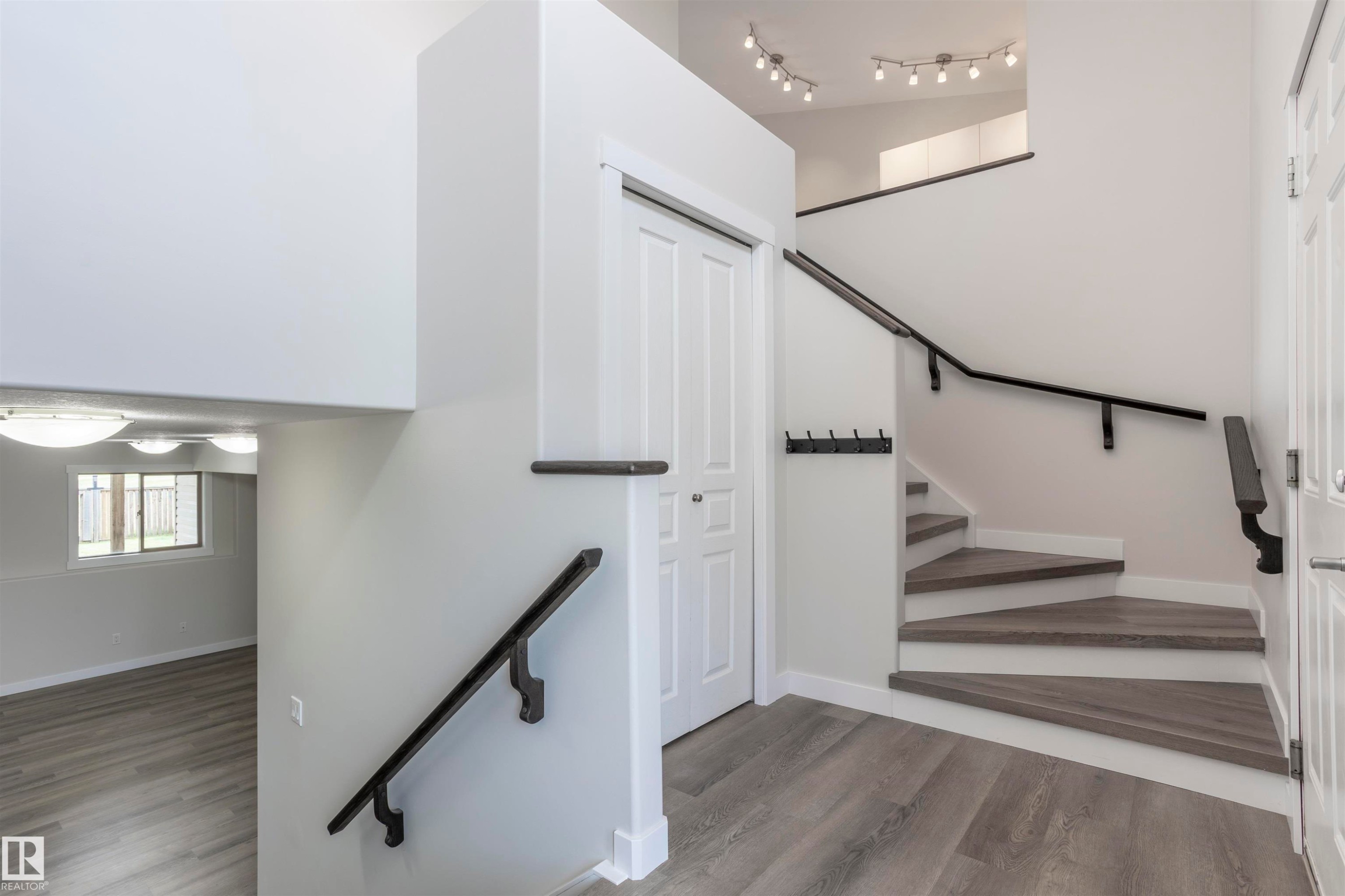Modern staircase featuring wood-finish treads and risers with dark handrails - 738 Kananaskis Drive, Devon, AB - Indoor Photo Showing Other Room
