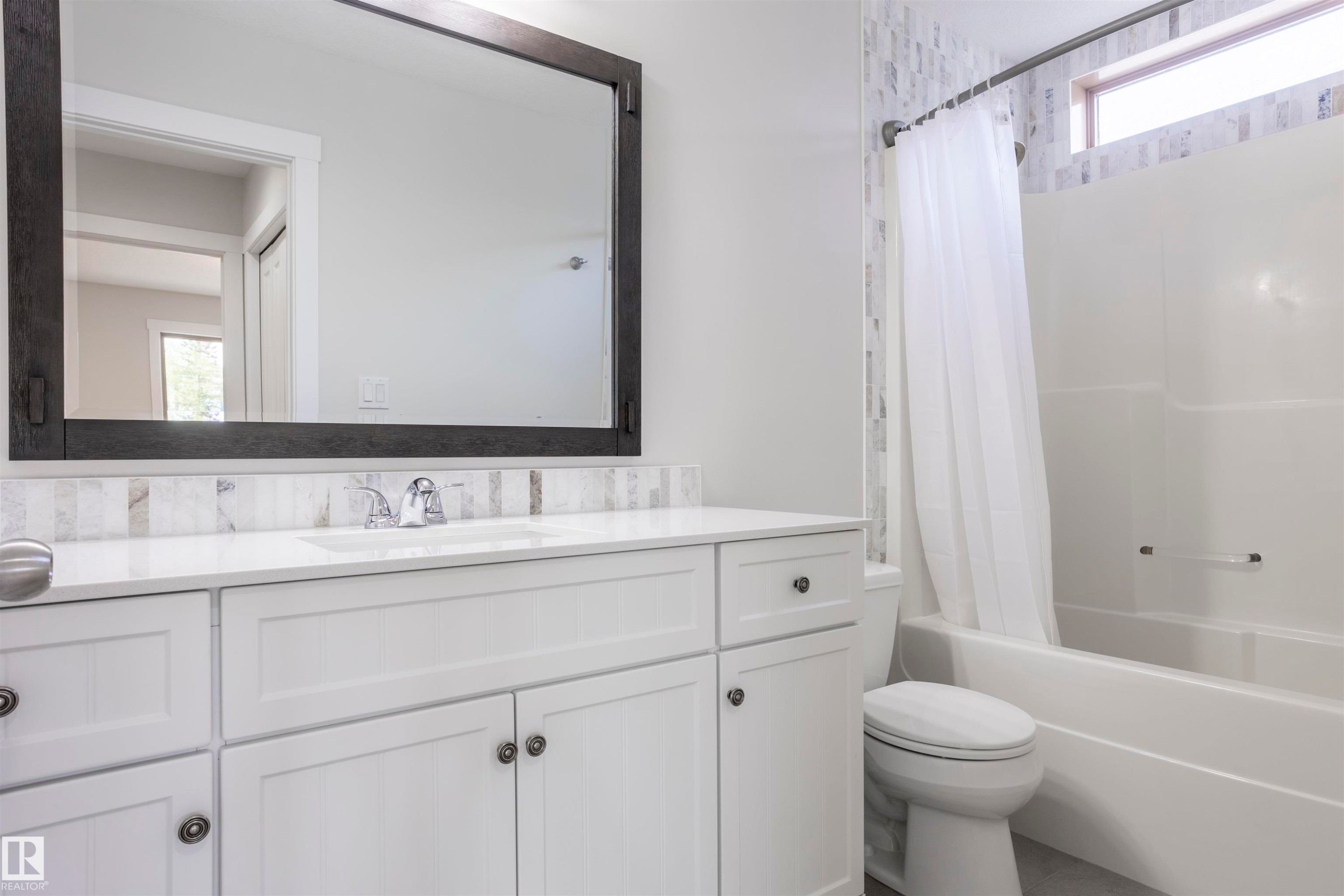 Bathroom featuring a white vanity with integrated sink, chrome faucet, and quartz countertop - 738 Kananaskis Drive, Devon, AB - Indoor Photo Showing Bathroom