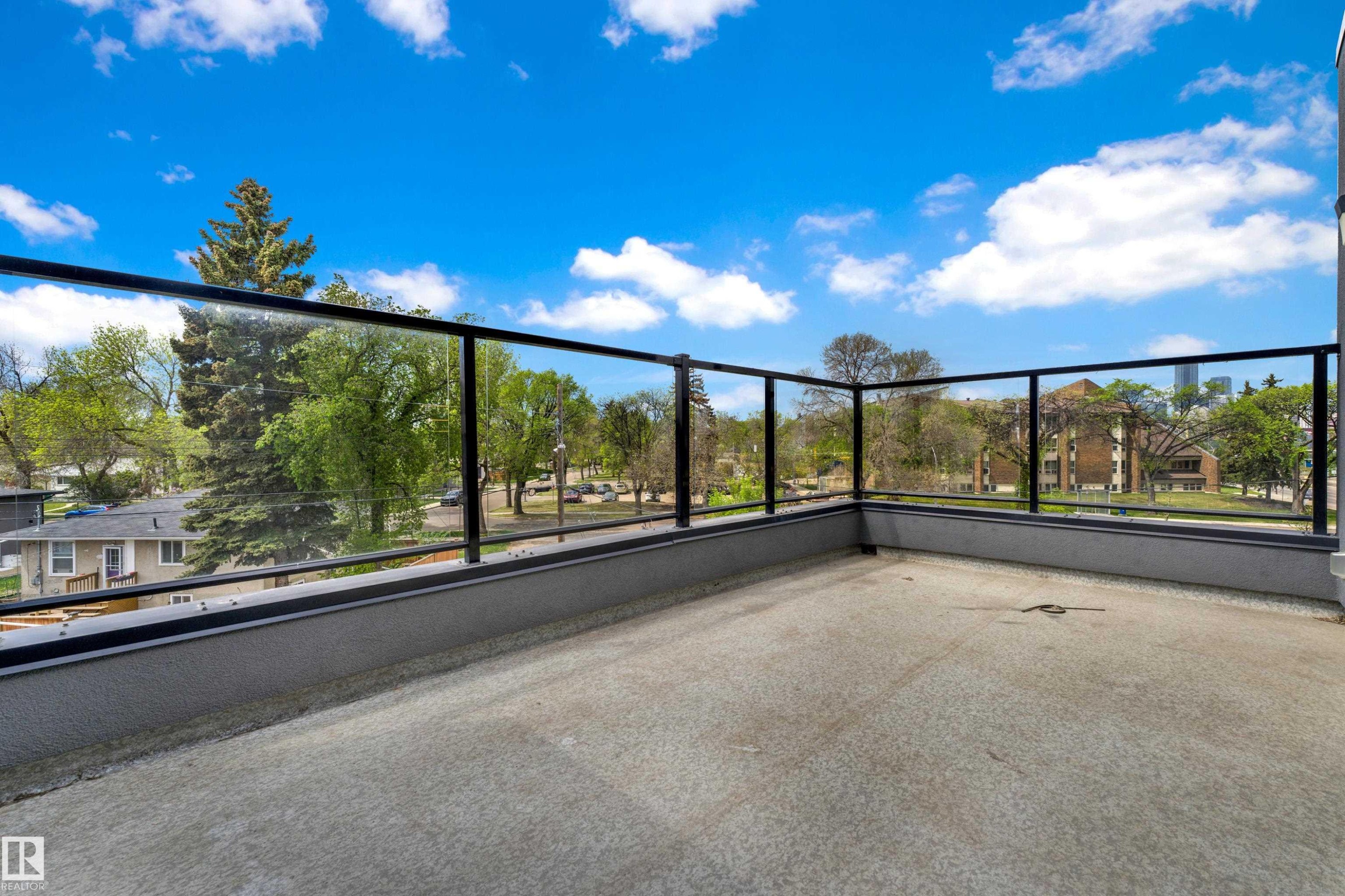 Outdoor patio featuring concrete flooring and modern glass railings with black frames - 9329 Connors Road, Edmonton, AB - Outdoor With View