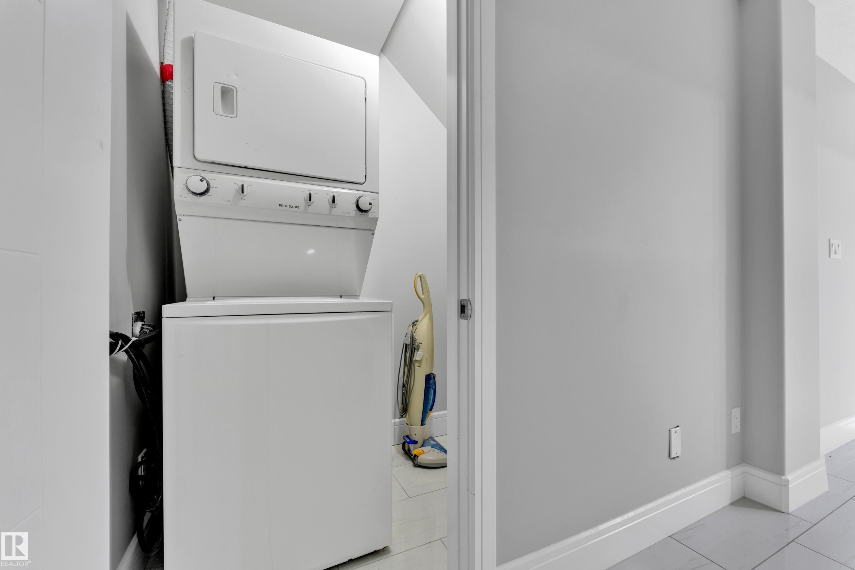Dedicated laundry area featuring a stacked washer and dryer unit - 9329 Connors Road, Edmonton, AB - Indoor Photo Showing Laundry Room