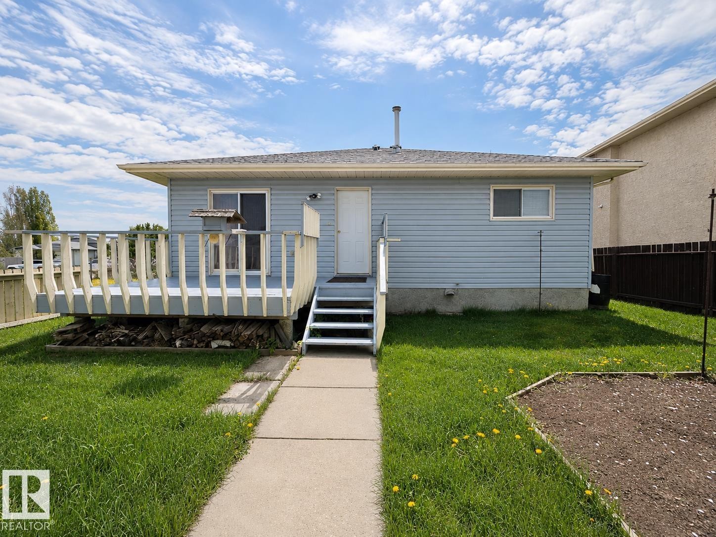 Rear exterior featuring light blue siding and a light gray deck - 4005 55 Avenue, Whitecourt, AB - Outdoor With Deck Patio Veranda