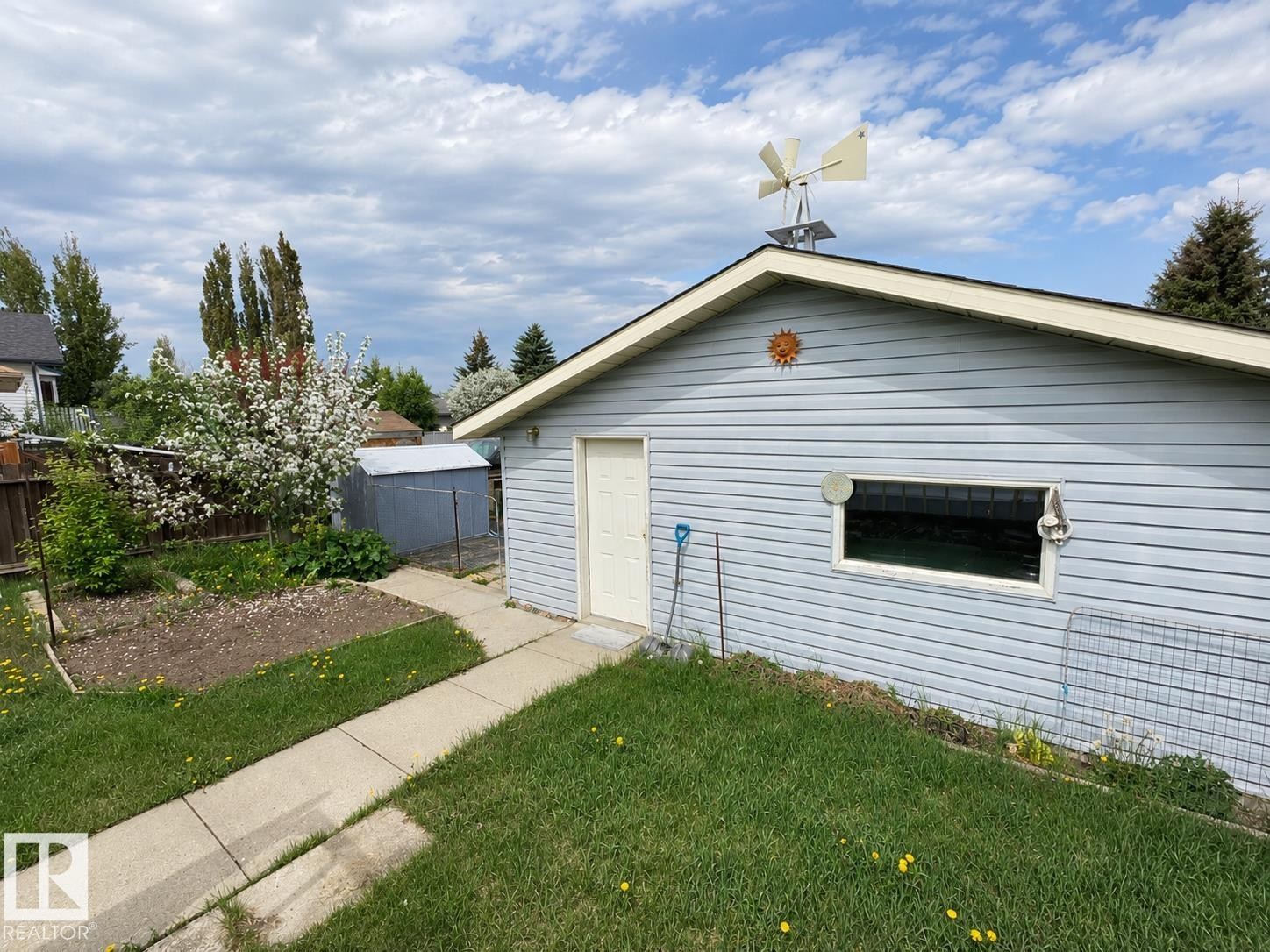 Detached garage with light blue horizontal siding, white trim, and a pedestrian door - 4005 55 Avenue, Whitecourt, AB - Outdoor