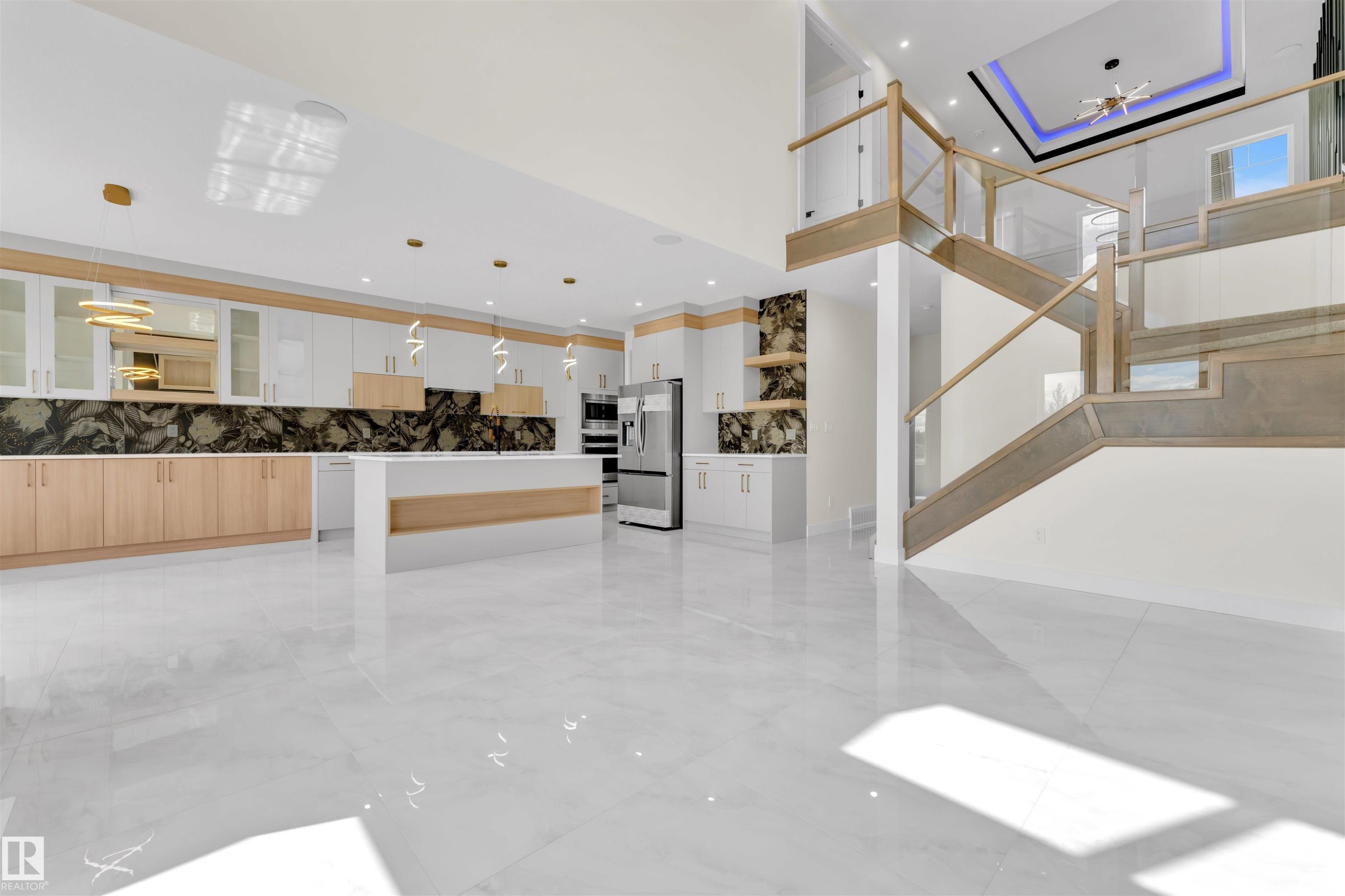 Open-concept living area featuring a modern kitchen with a large island, stainless steel appliances, and contrasting cabinetry - 2027 156 Avenue, Edmonton, AB - Indoor Photo Showing Other Room