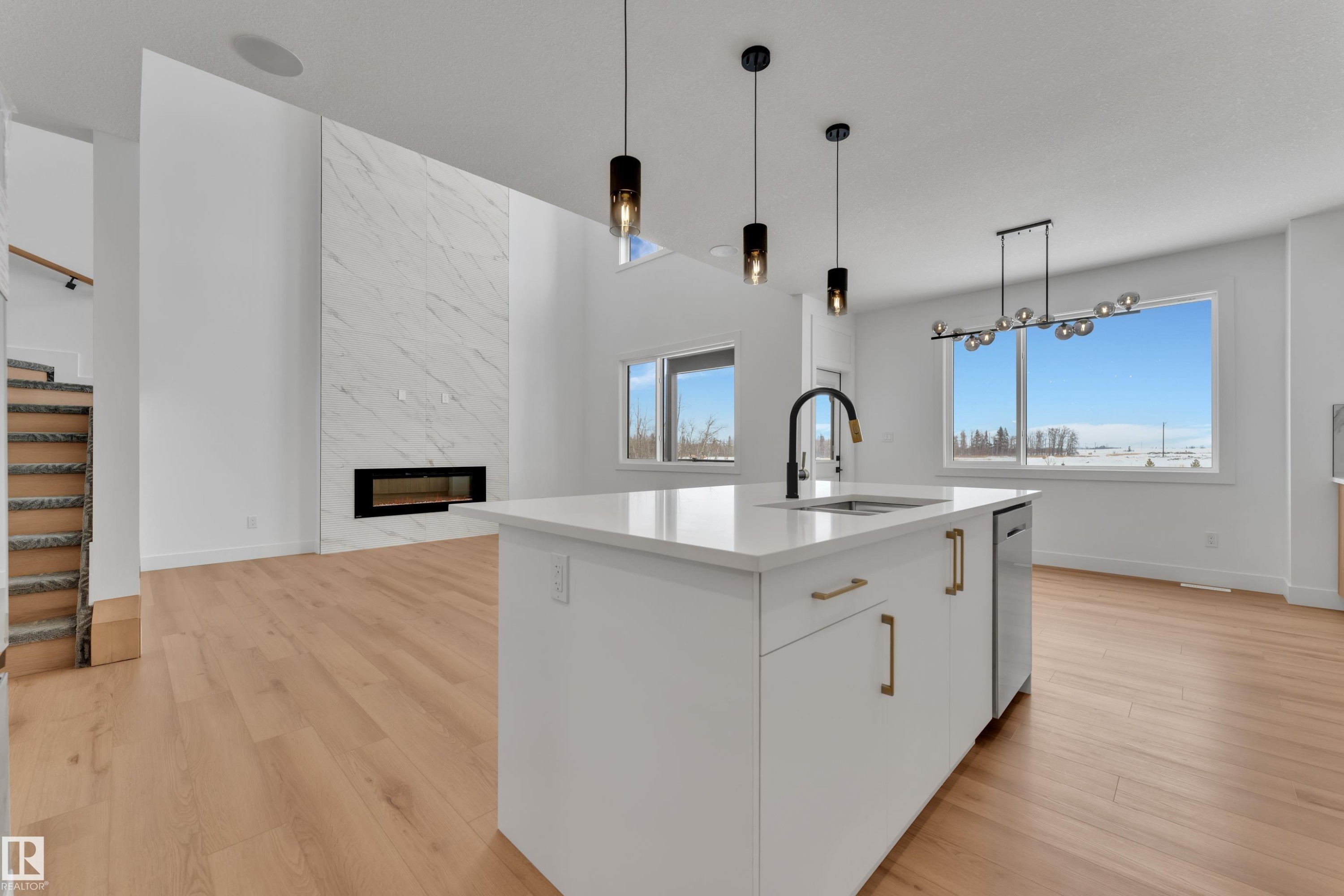 Modern kitchen island with a white countertop, undermount sink, and black gooseneck faucet - 2027 156 Avenue, Edmonton, AB - Indoor Photo Showing Kitchen With Upgraded Kitchen