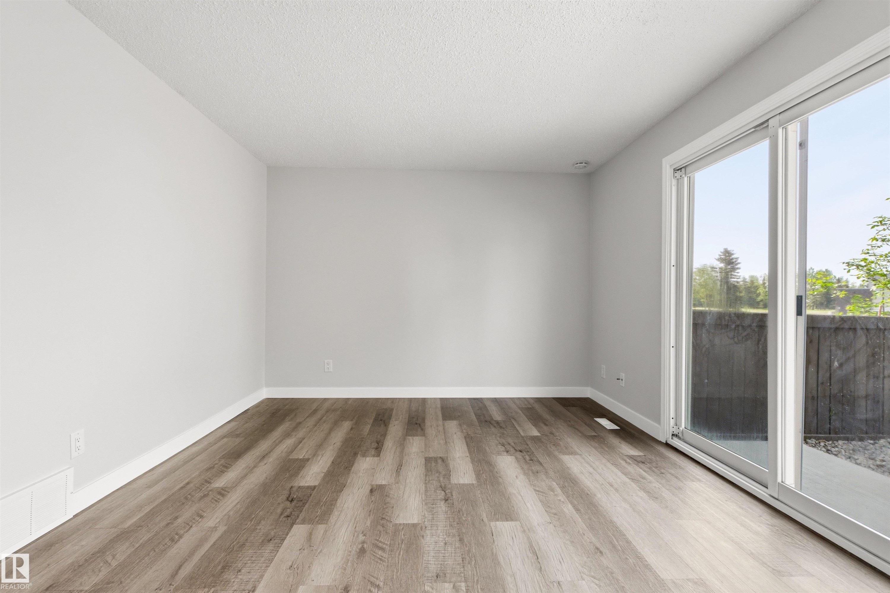 Spacious room with wood-finish flooring, light grey walls, and white trim - 707 Clareview Road, Edmonton, AB - Indoor Photo Showing Other Room