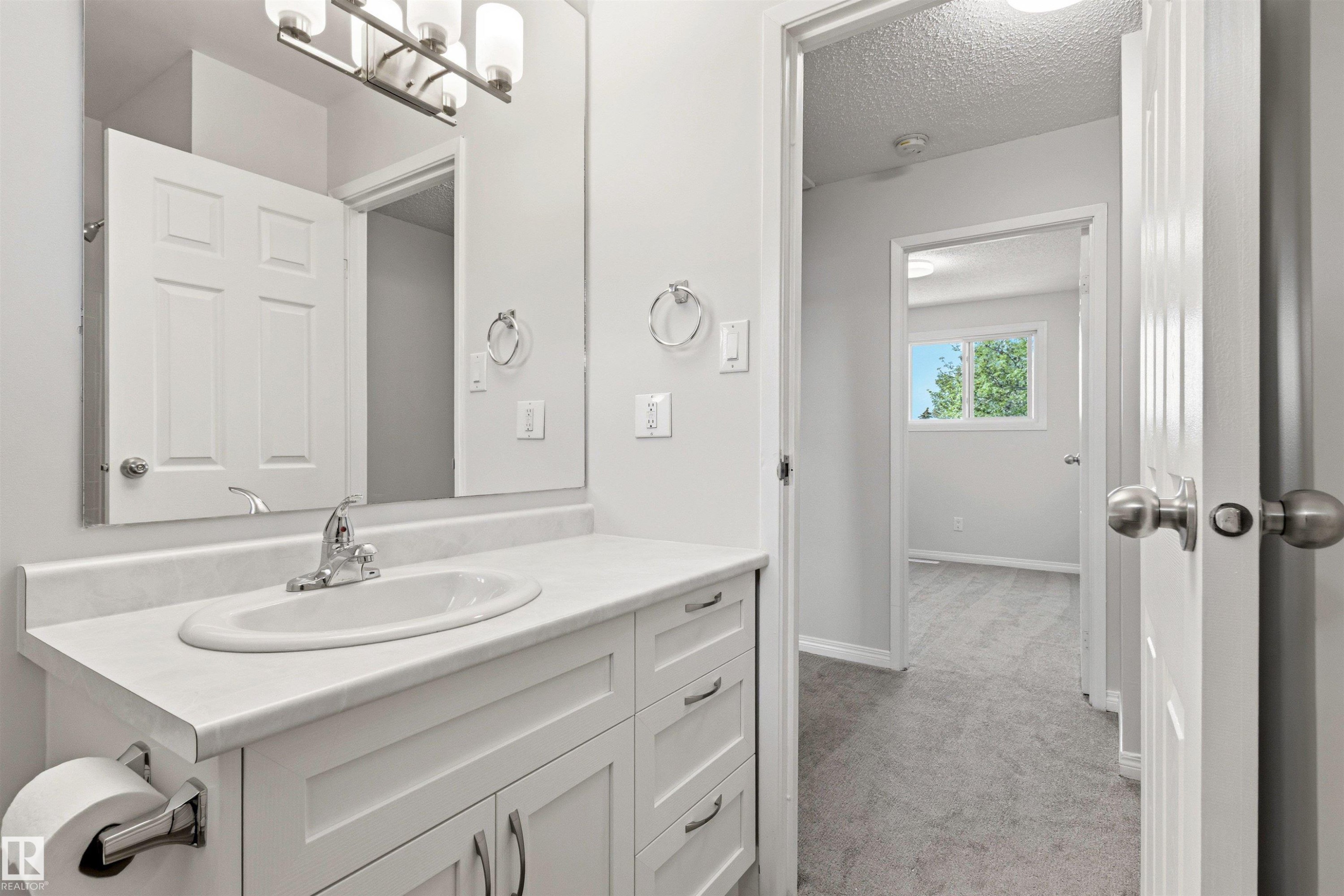 Bathroom vanity featuring a white countertop, oval undermount sink, and chrome faucet - 707 Clareview Road, Edmonton, AB - Indoor Photo Showing Bathroom