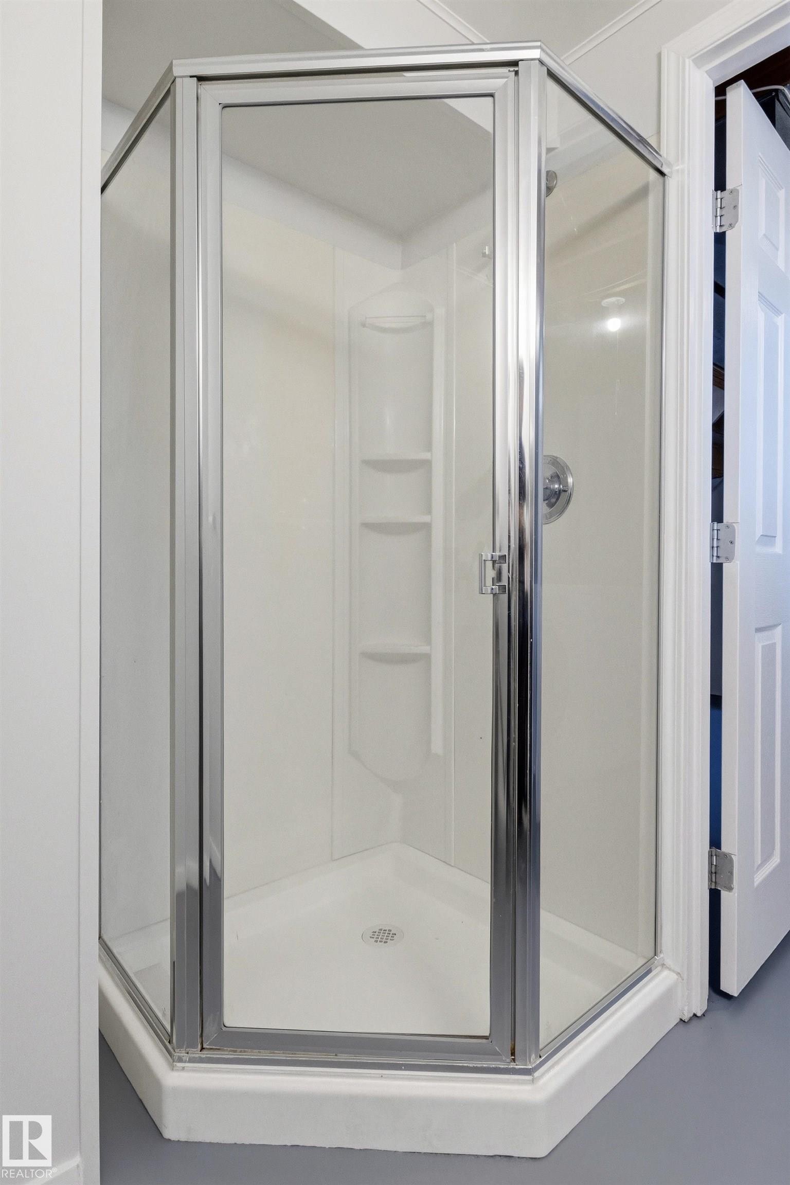 Corner shower enclosure featuring clear glass panels and chrome framing - 707 Clareview Road, Edmonton, AB - Indoor Photo Showing Bathroom