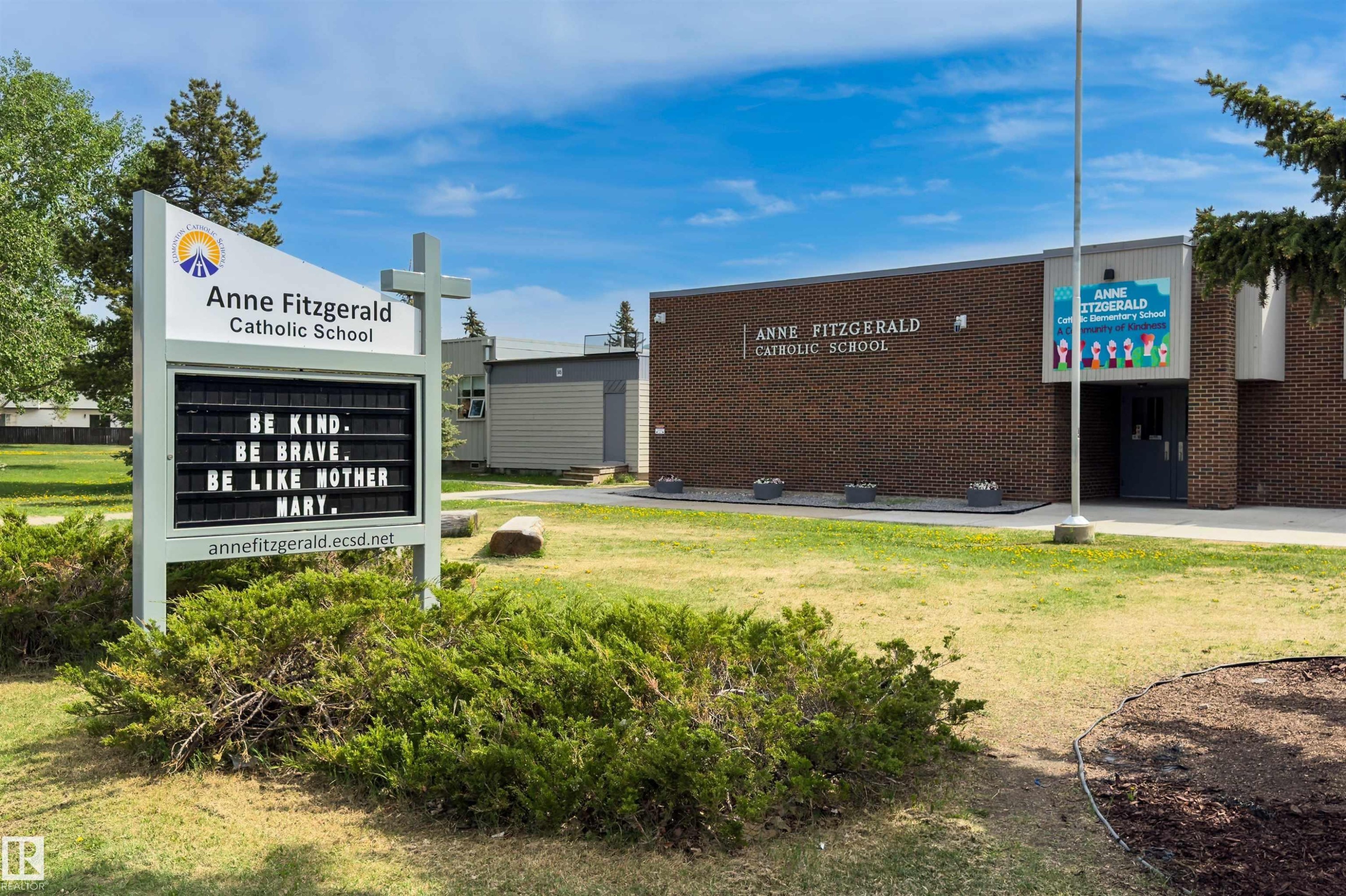 Brick exterior building with a prominent school sign featuring a cross accent - 707 Clareview Road, Edmonton, AB - Outdoor