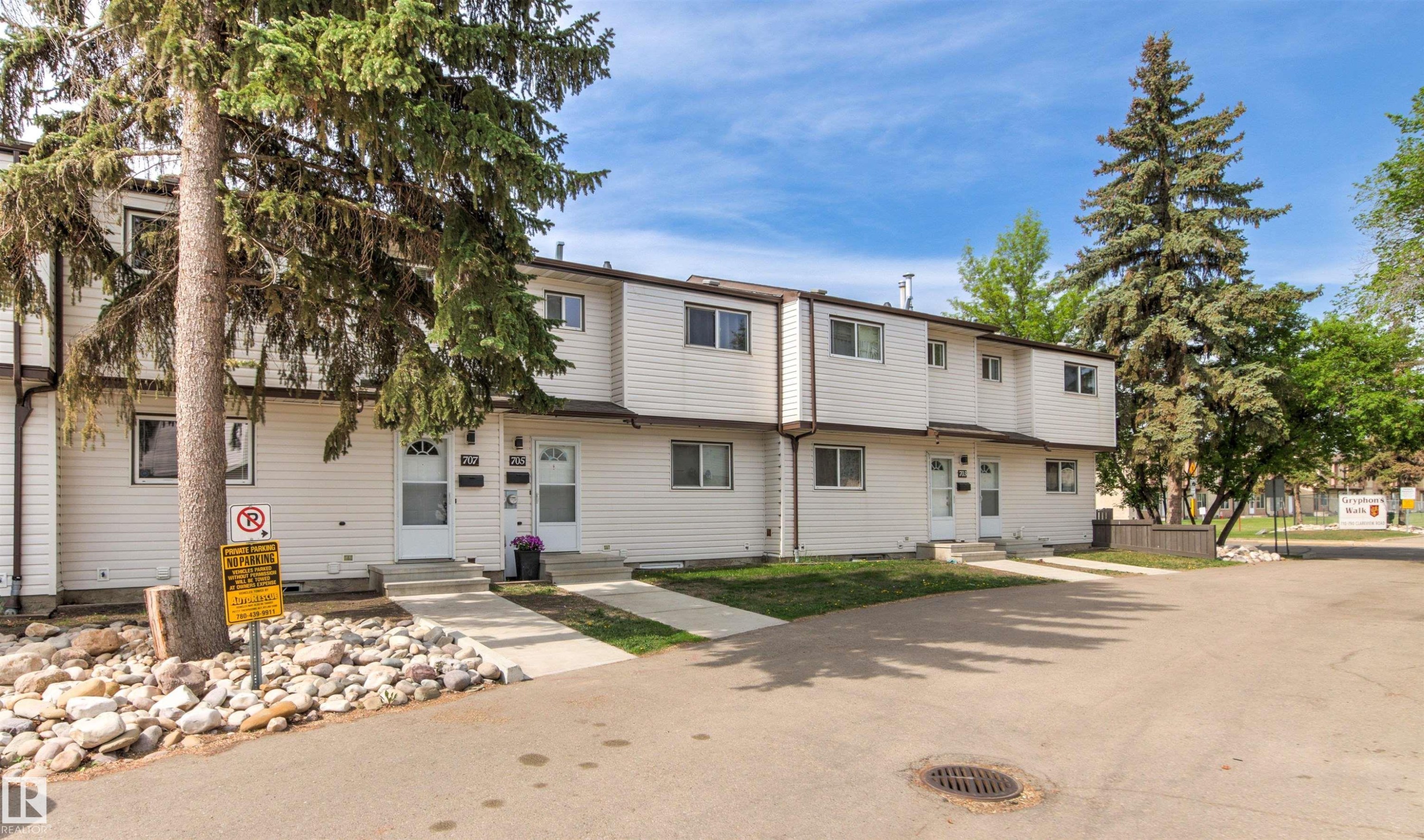 Row of townhomes featuring white siding and individual entryways - 707 Clareview Road, Edmonton, AB - Outdoor With Facade