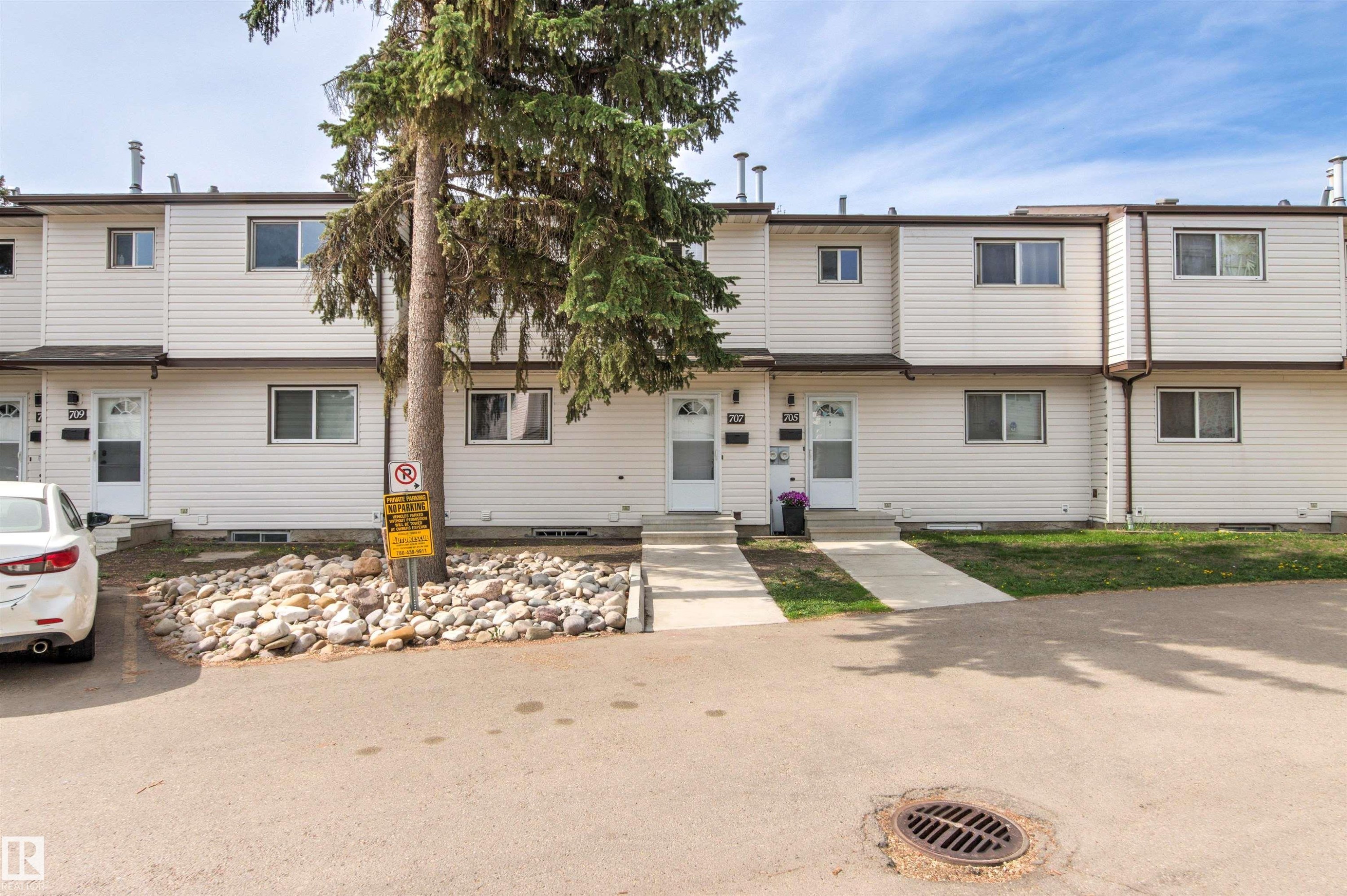 Row of townhomes featuring white siding and brown trim - 707 Clareview Road, Edmonton, AB - Outdoor With Facade